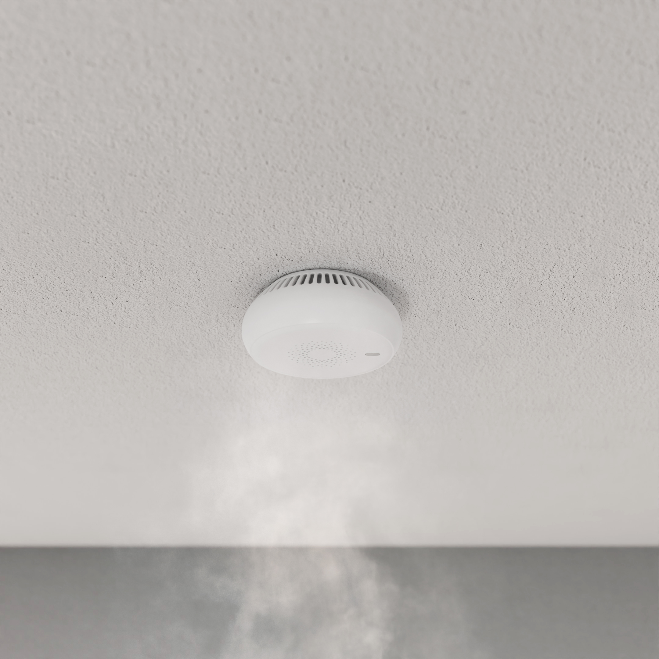 Weißer Rauchmelder an einer weißen Decke. Rauch ist unterhalb des Melders sichtbar.