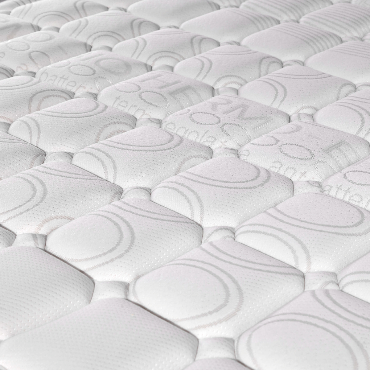 Primer plano de colchón blanco, mostrando superficie acolchada con patrón repetitivo.
