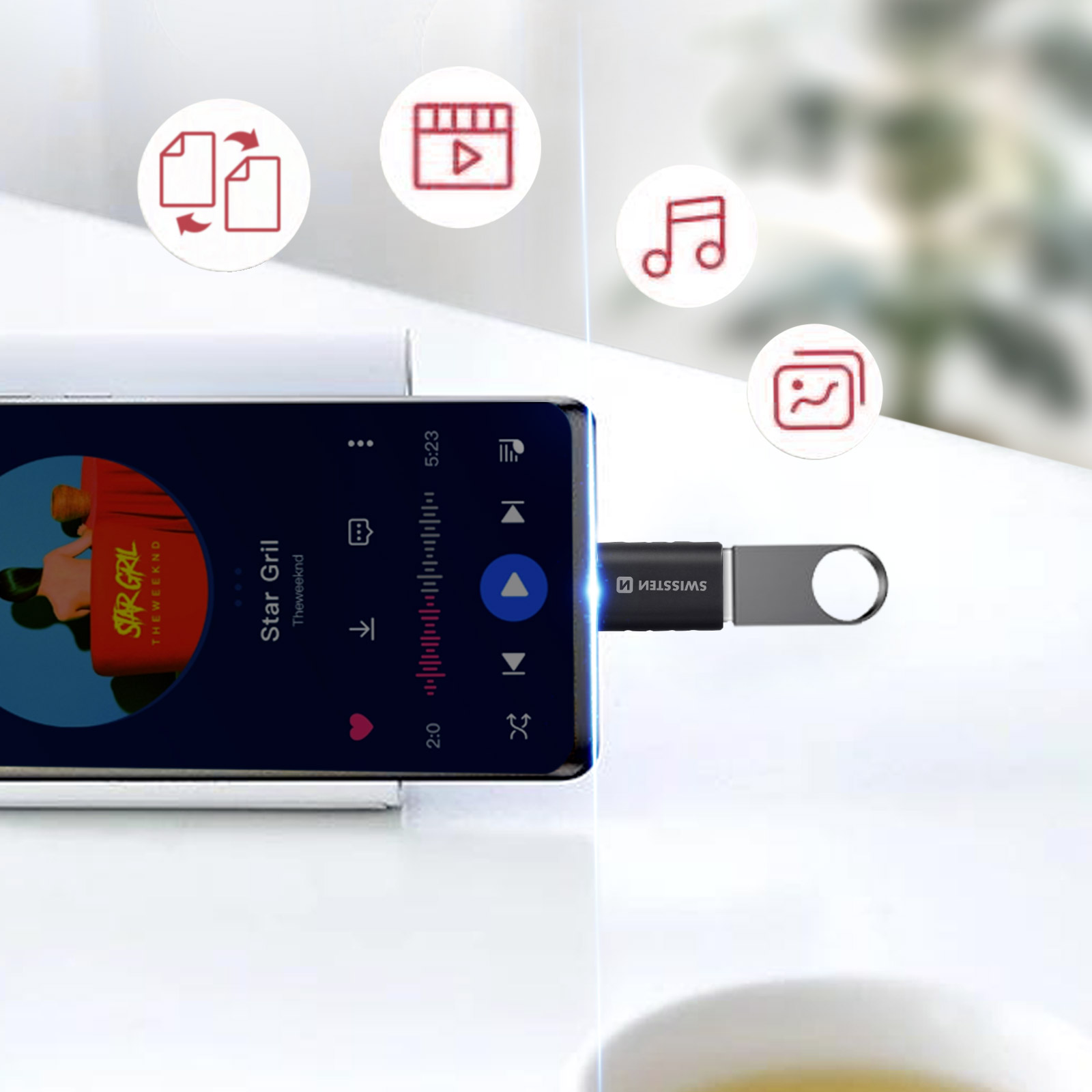 Ein Smartphone mit Musik-Player-Oberfläche ist mit einem USB-Stick verbunden. Über dem Telefon befinden sich Symbole.