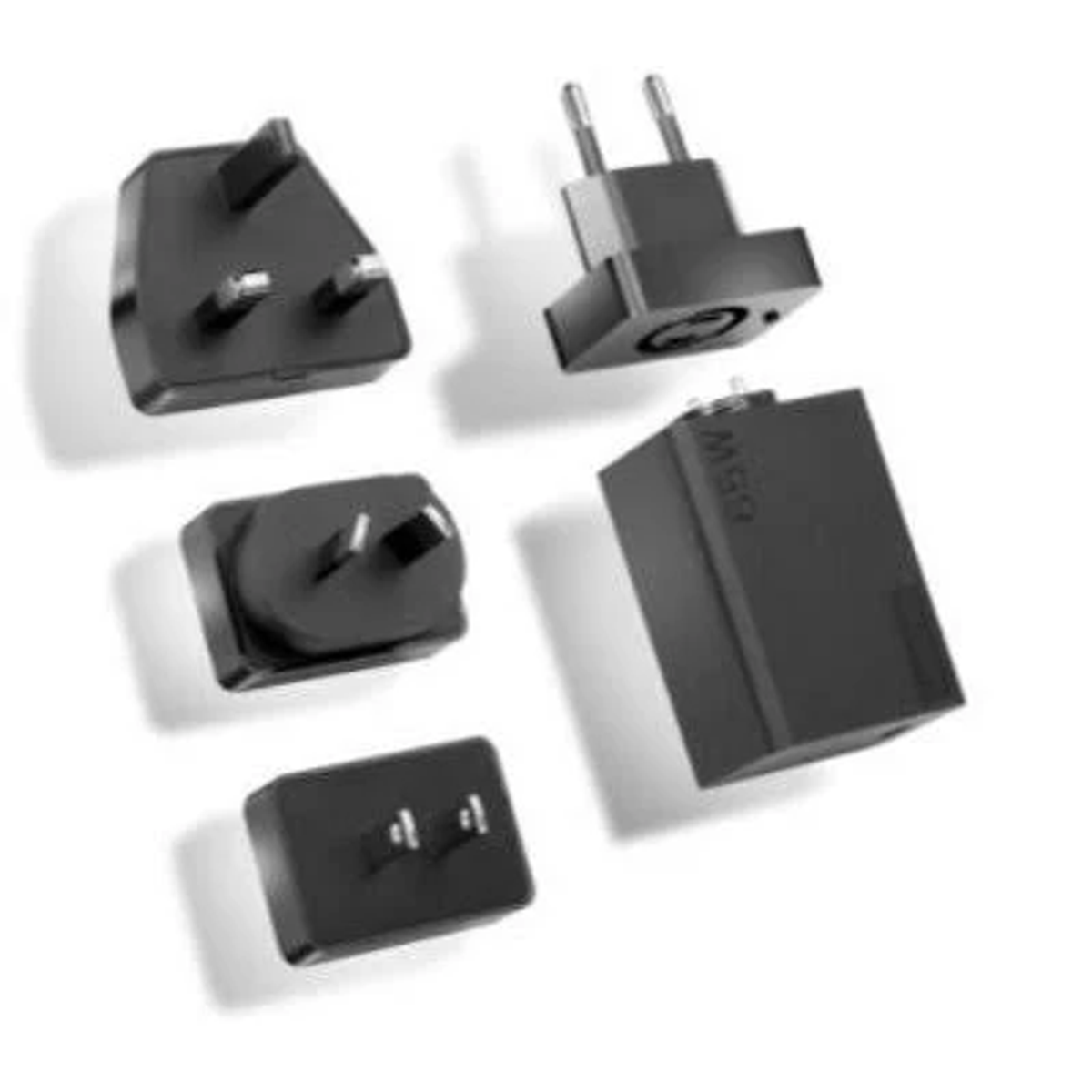 Adaptadores de corriente negros variados en varias formas, sobre fondo blanco.