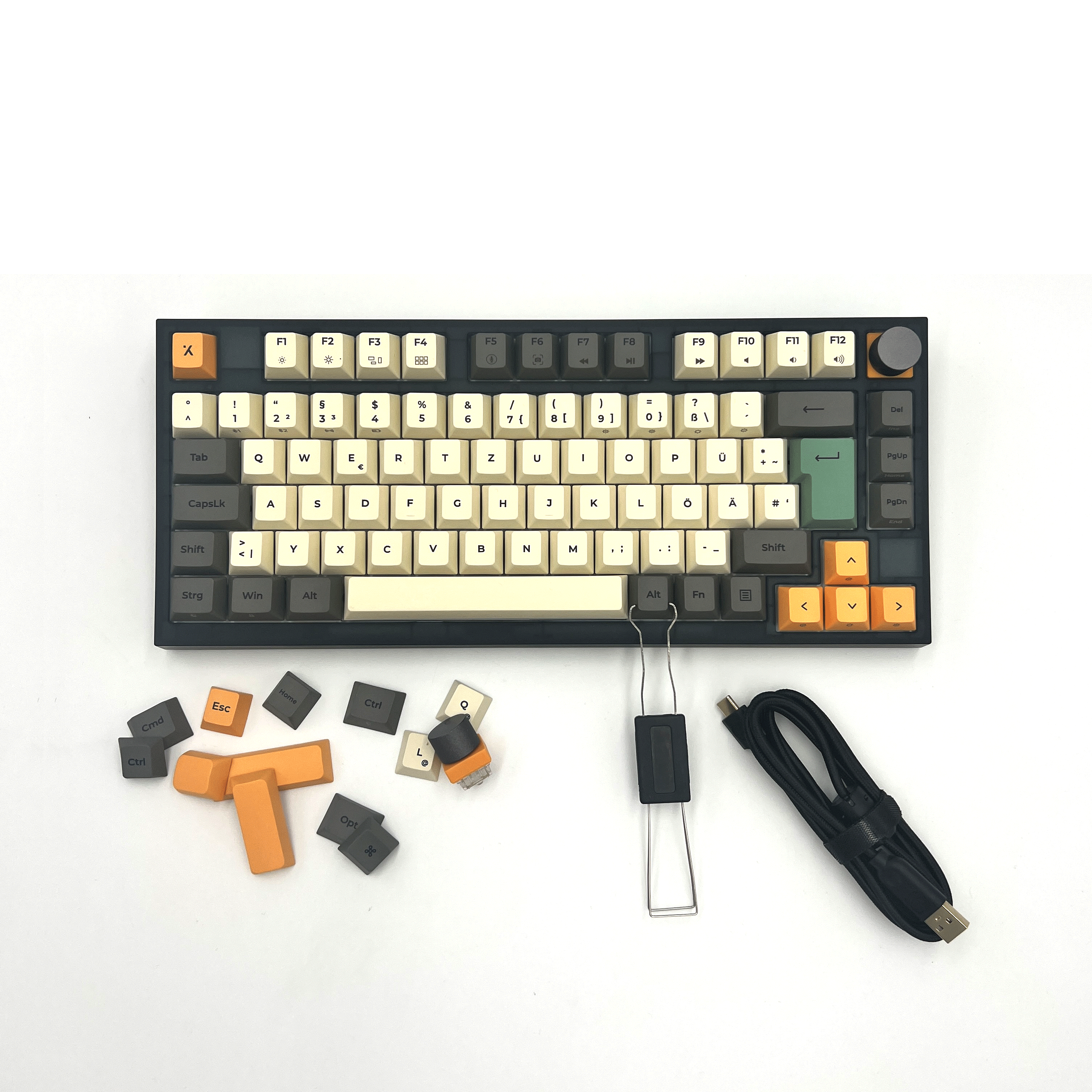 Eine mechanische Tastatur mit Keycaps, Keycap-Abzieher und USB-Kabel.