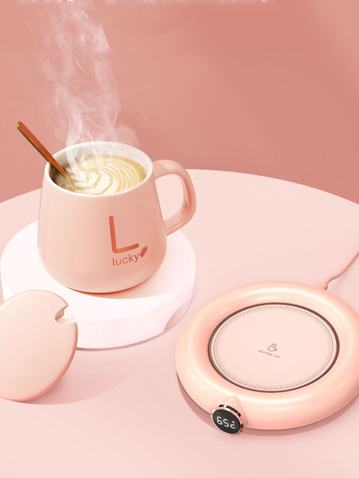 Rosa Tasse mit Löffel, auf rosa Wärmer, Dampf steigt auf, rosa Hintergrund.