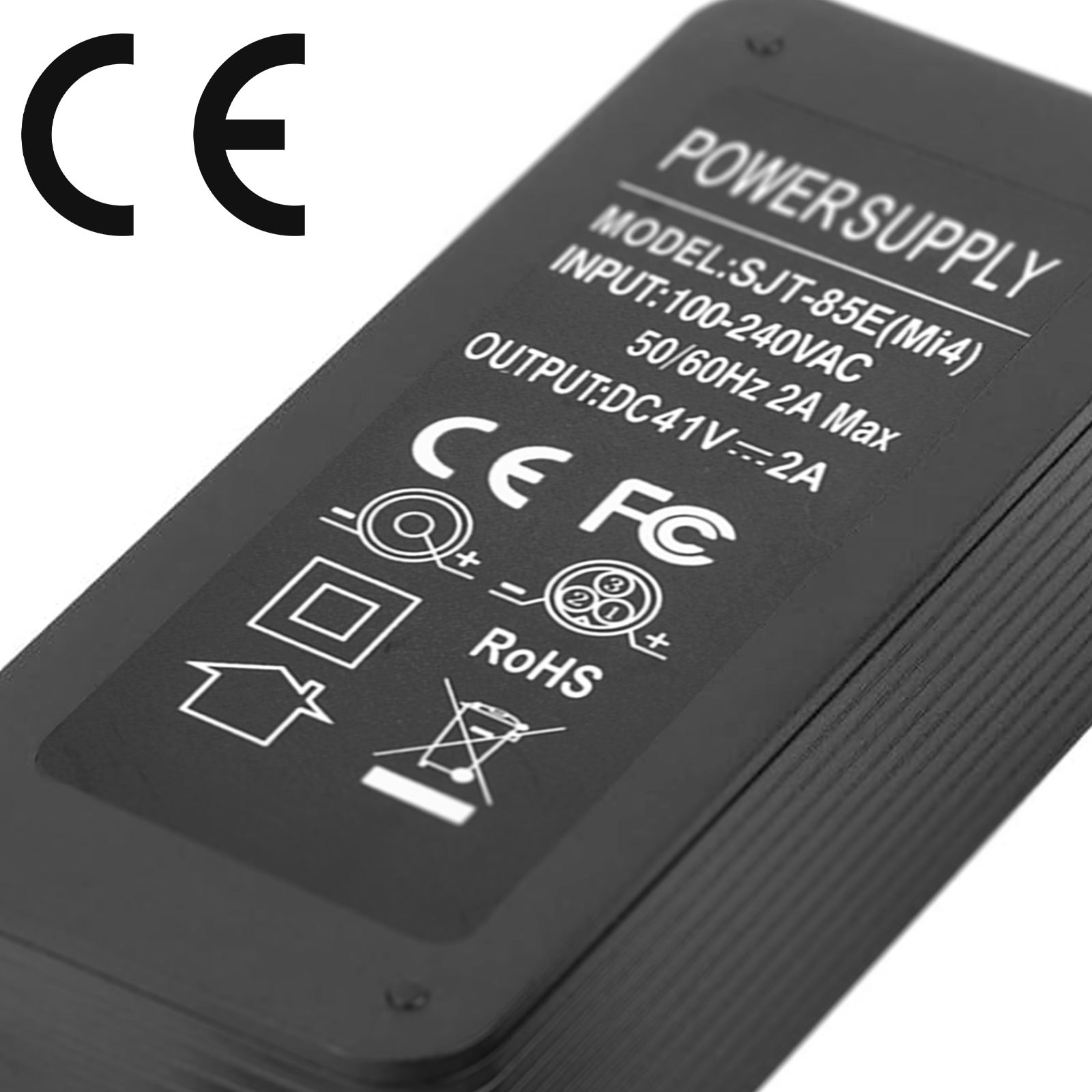 Un alimentatore nero con etichette, inclusi marchi CE e FC, e un diagramma.