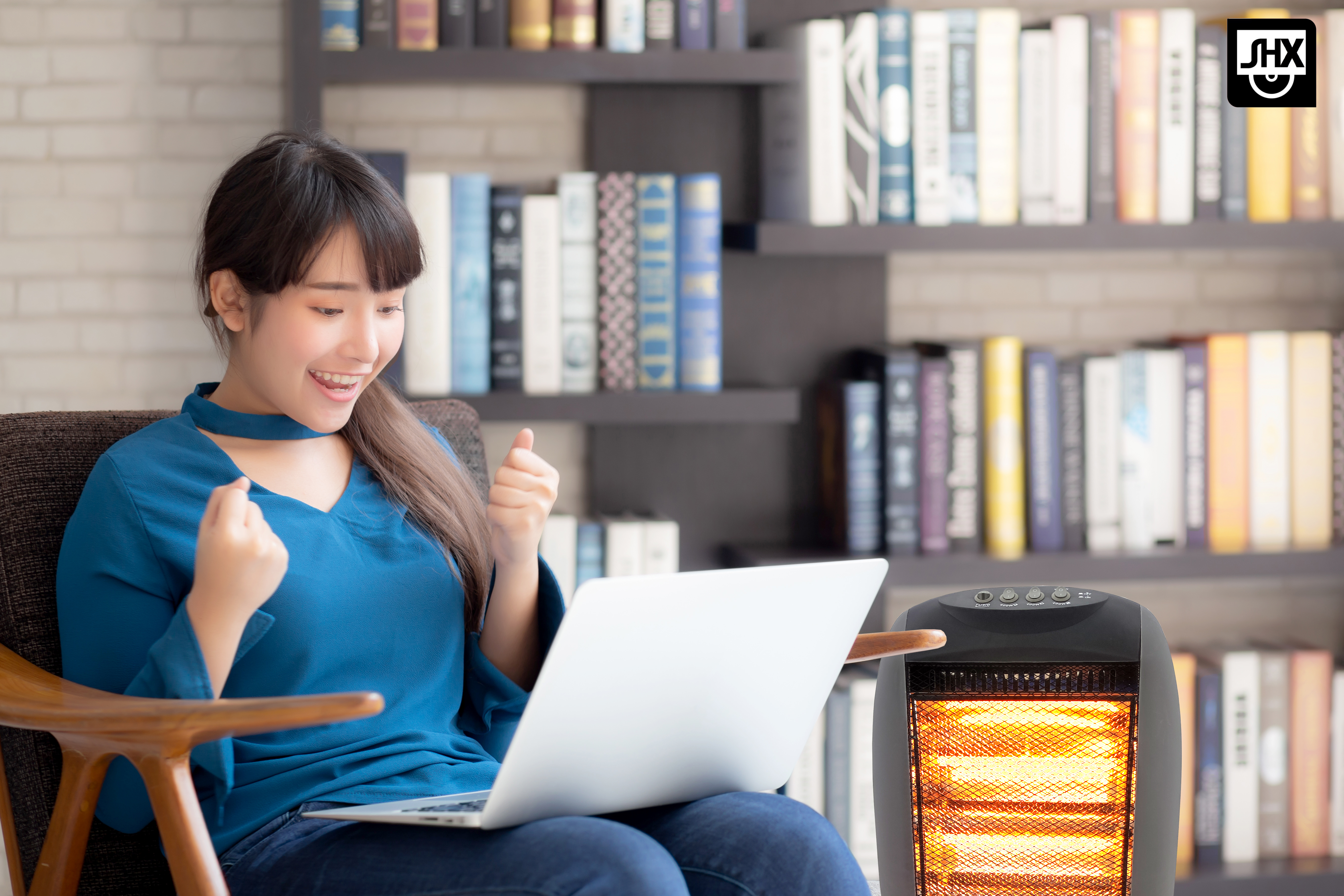 Donna felice con laptop davanti a libreria e stufa.