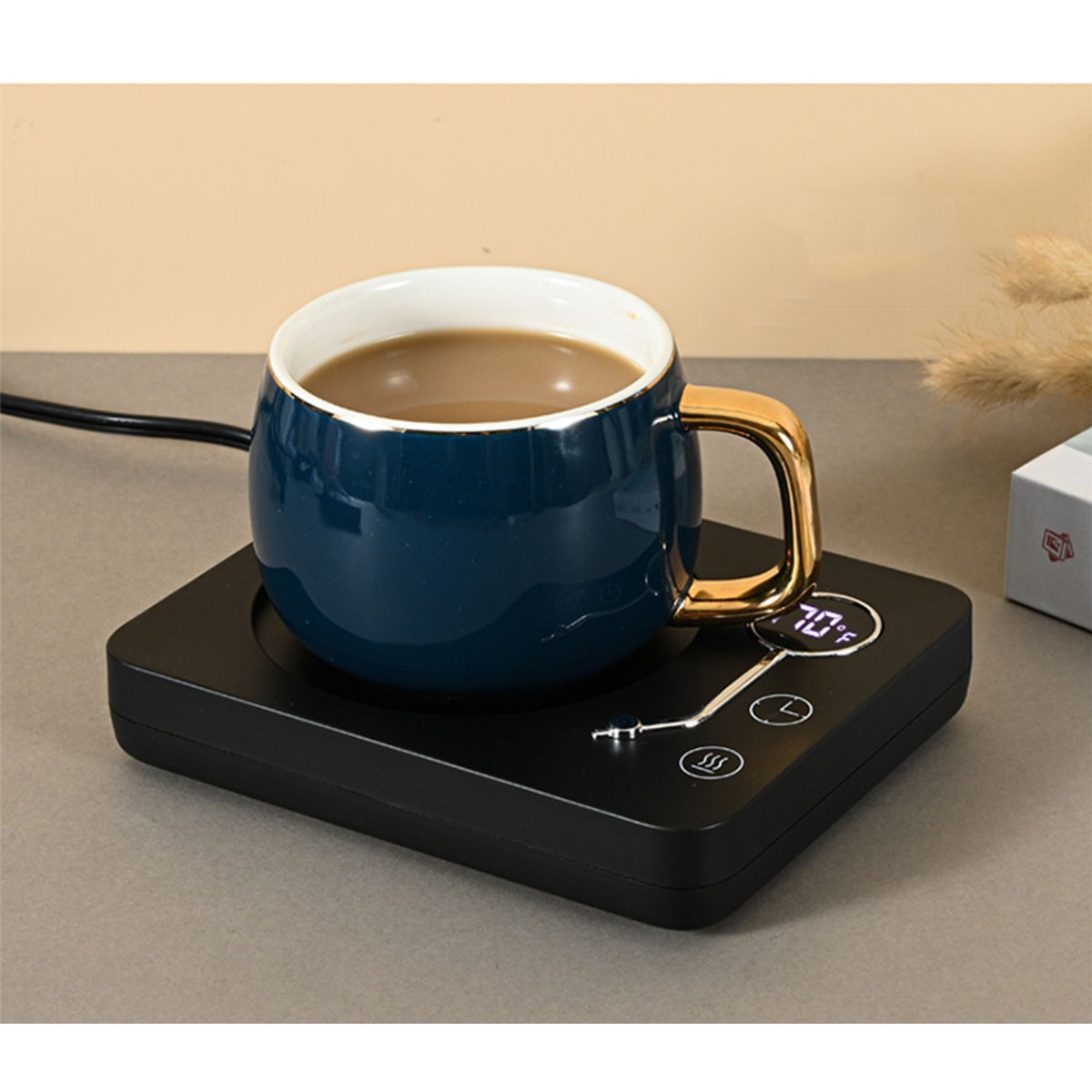 Eine dunkelblaue Tasse mit goldenem Griff steht auf einem schwarzen Wärmer. Kaffee ist drin. 70°F werden gezeigt.