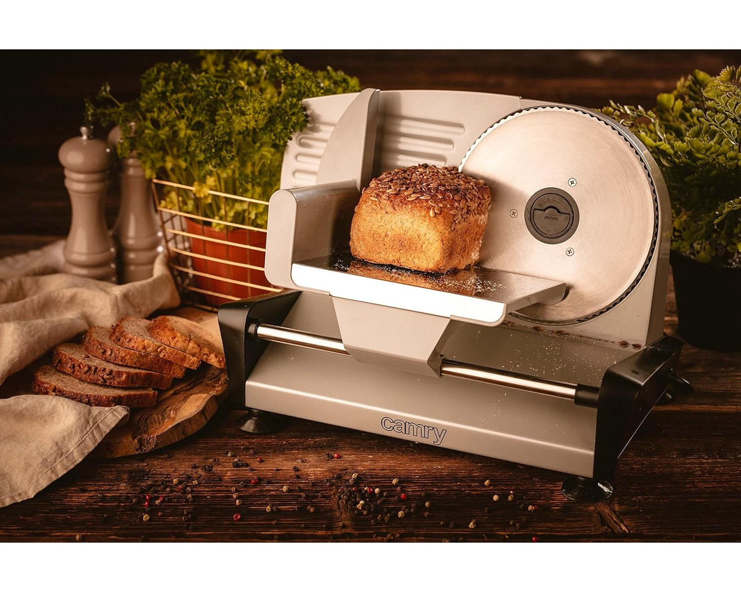 Eine Brotschneidemaschine mit einem Brotlaib darauf. Vorne liegen Brotscheiben.
