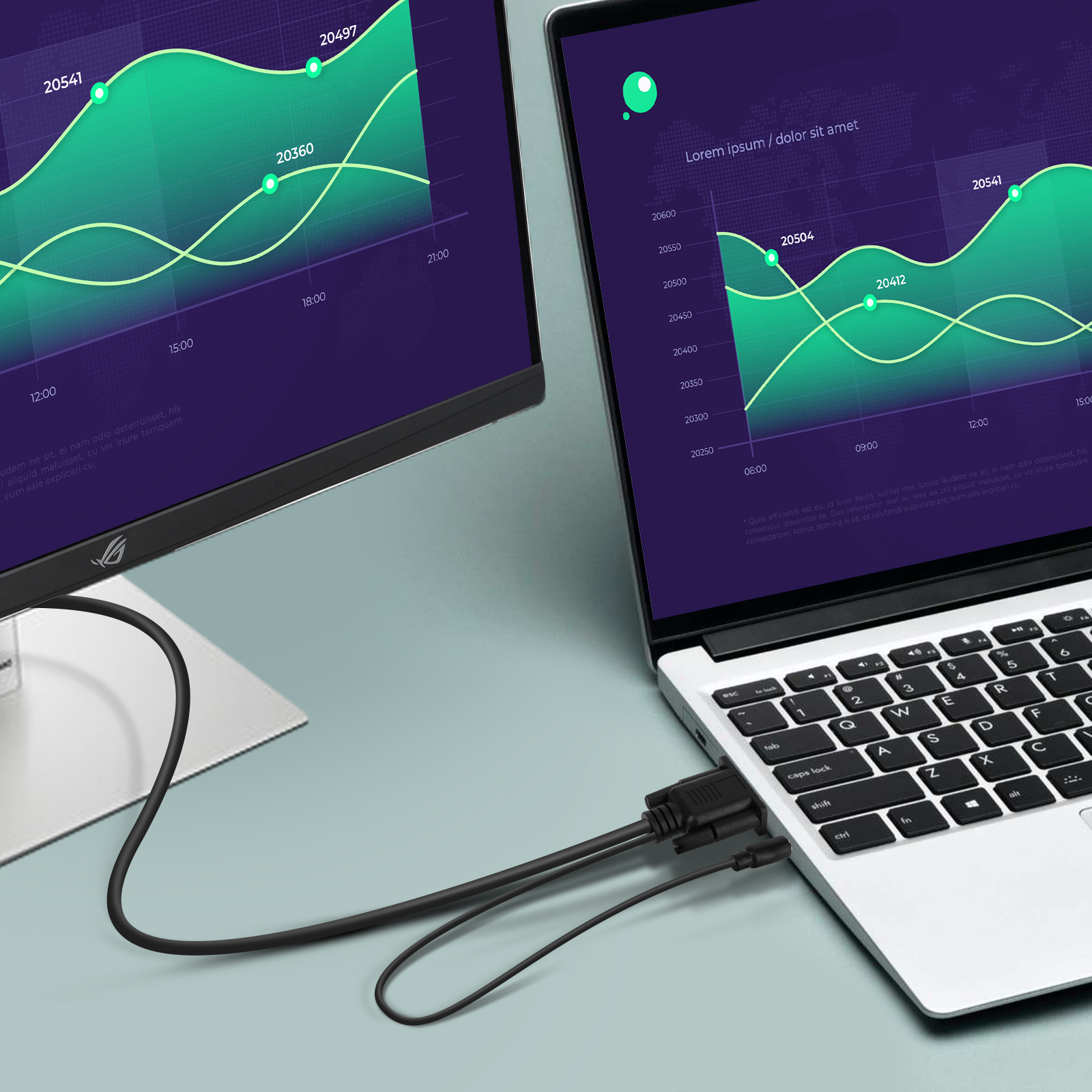 Un laptop collegato a un monitor tramite un cavo, che mostra grafici e dati sugli schermi.