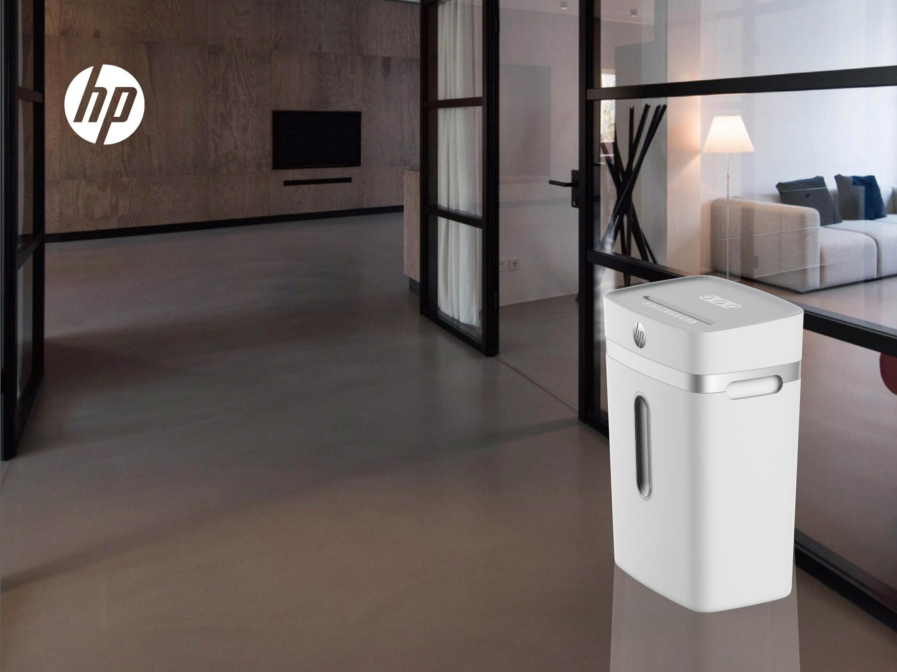 Biała niszczarka do papieru w otoczeniu biurowym. Tło obejmuje pokój z drzwiami.