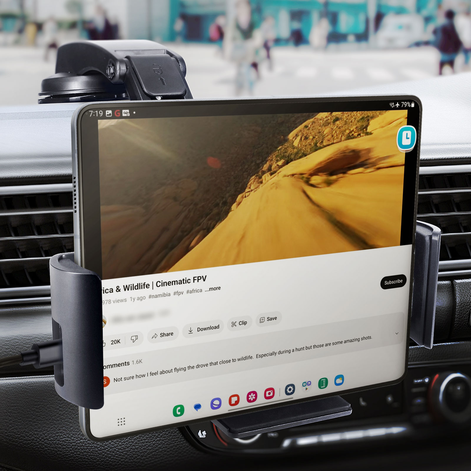 Tablet in Autohalterung zeigt Video. Hintergrund zeigt verschwommene Straßenszene.