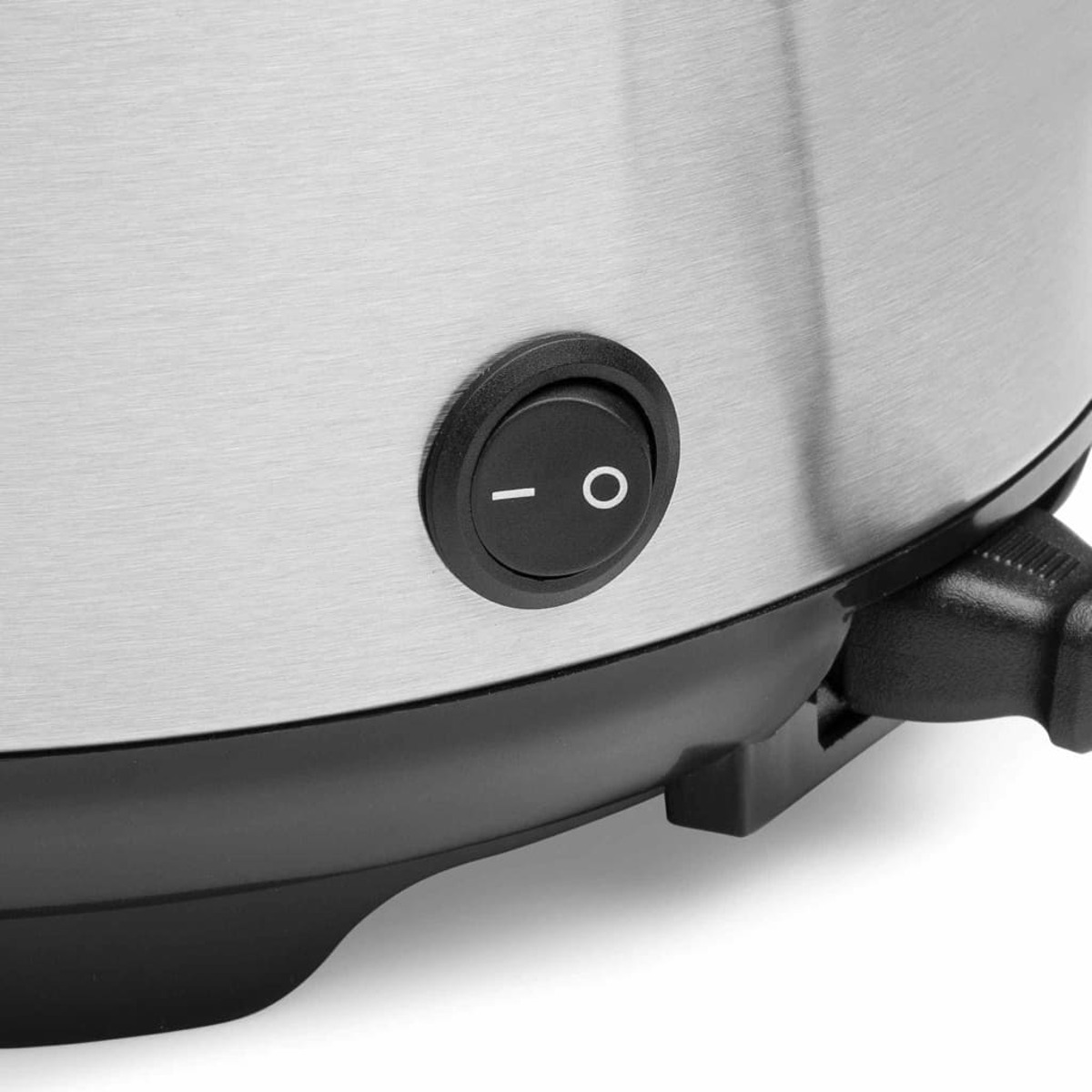 Schwarzer Einschaltknopf an einem metallischen Gerät, mit schwarzem Sockel. Nahaufnahme.