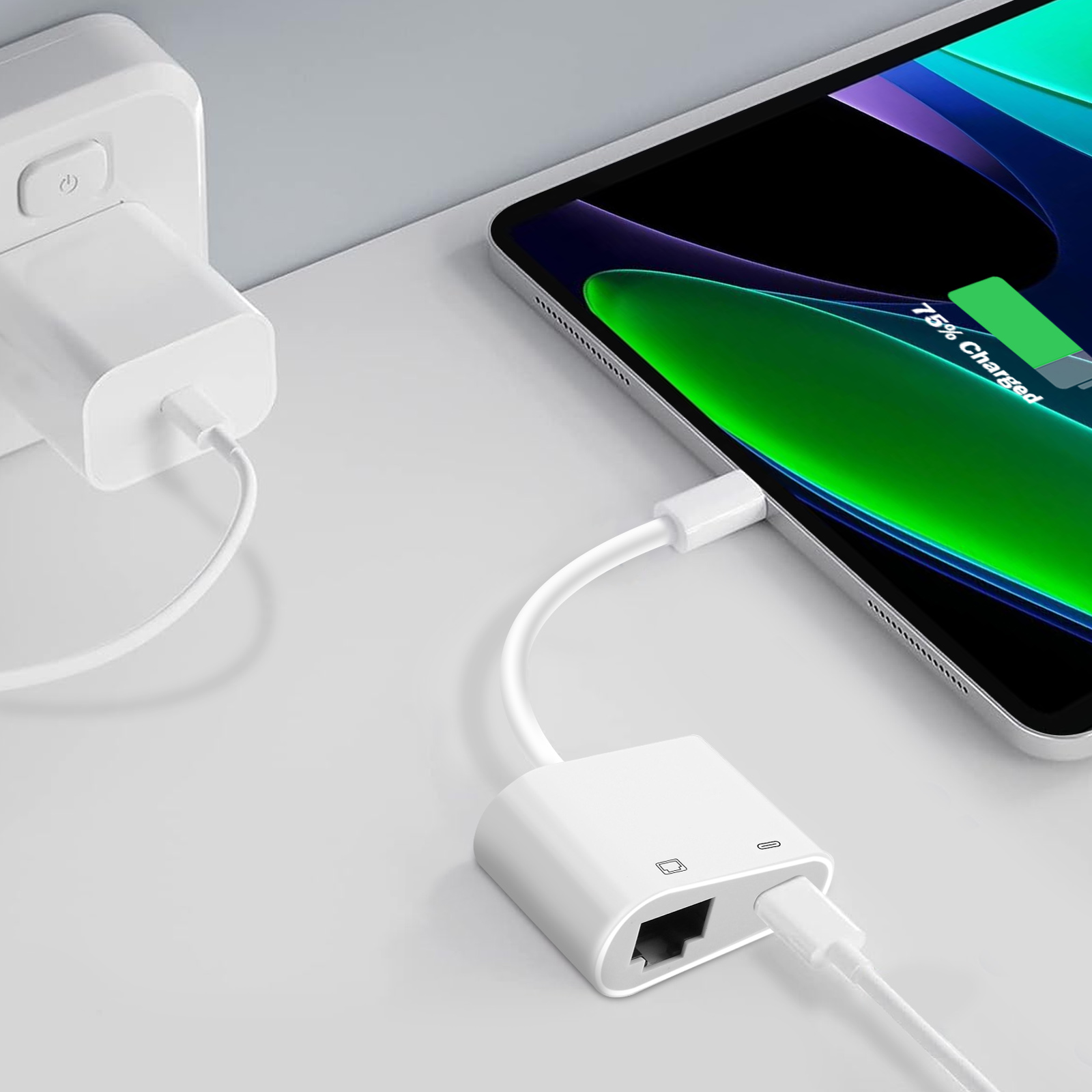 Adattatore bianco collegato a un tablet e a una presa a muro. Il tablet mostra il 75% di carica.