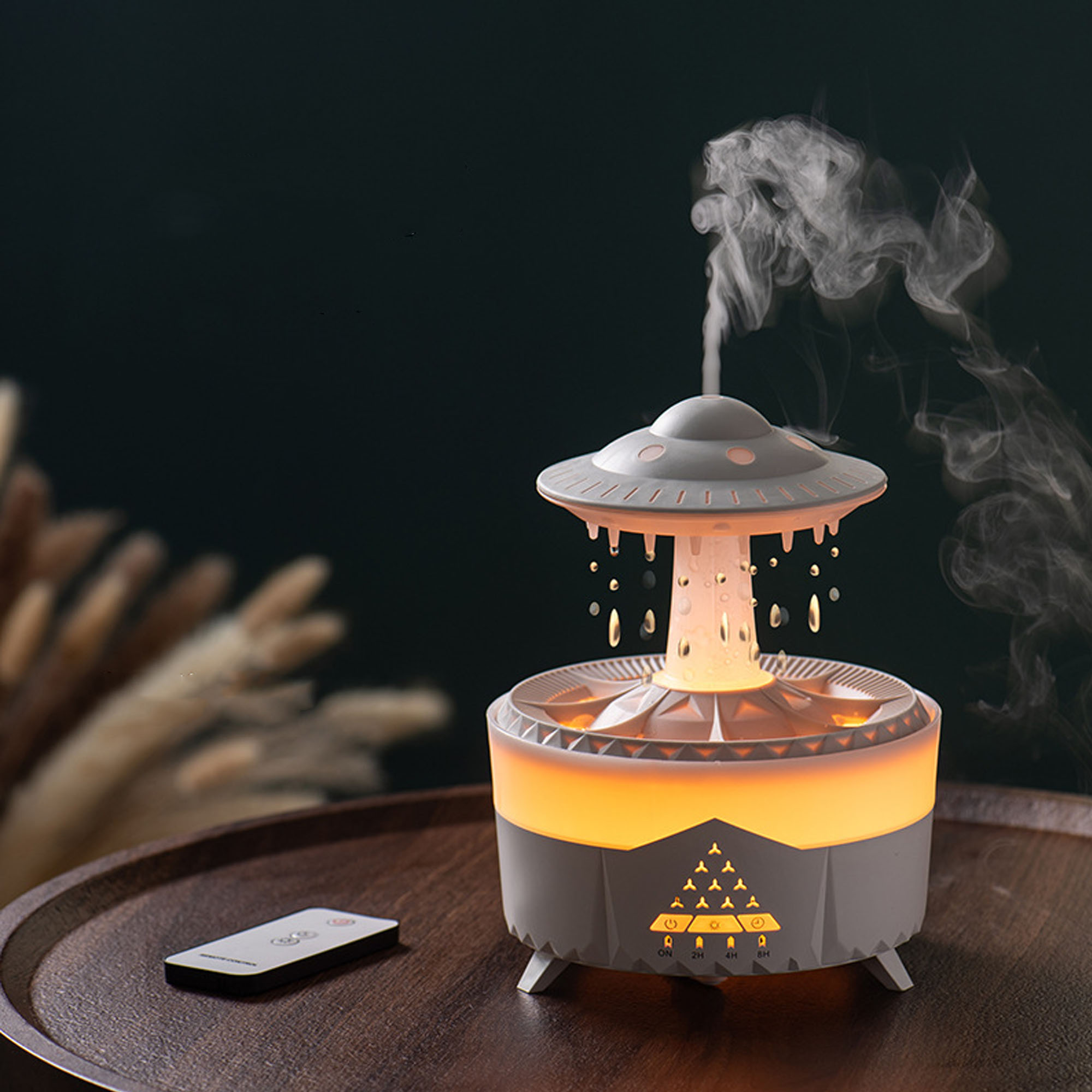 UFO-förmiger Aromadiffusor mit Dampf, Steuerung und Lichtern auf Tisch.