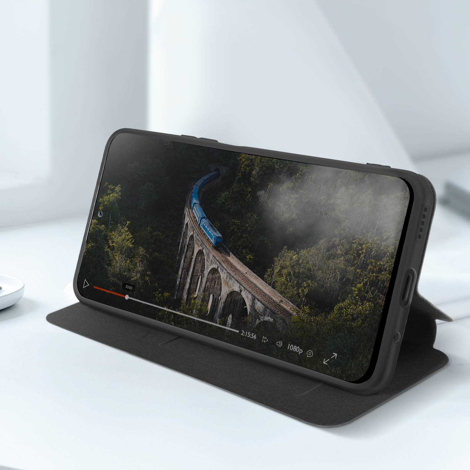Telefono su un supporto, che mostra un video di un treno su un ponte. Il telefono è nero.