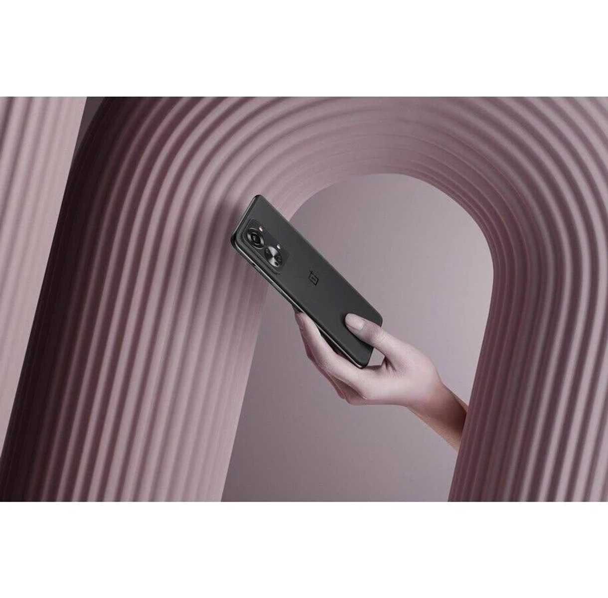 Black phone held by a hand. Phone has a camera and a black case.