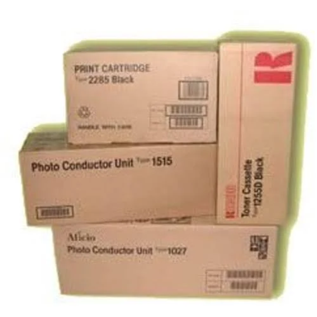 Ułożone w stosy pudełka z materiałami eksploatacyjnymi do drukarek. Etykiety z tekstem są widoczne na pudełkach. Mają różne rozmiary.