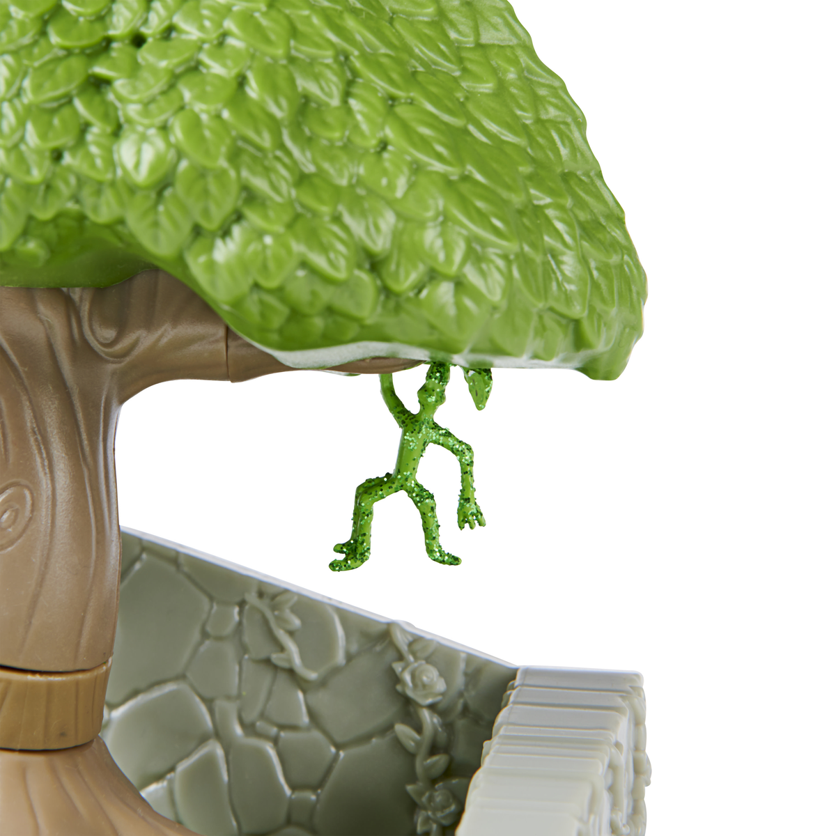 Zielona figurka zabawki zwisająca z gałęzi, część zestawu zabawek.