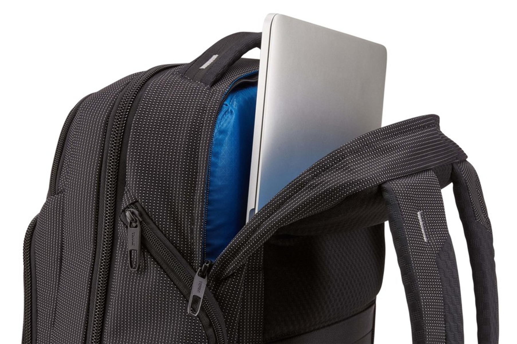 Rucksack mit Laptop in offener Tasche, schwarz mit weißen Punkten.