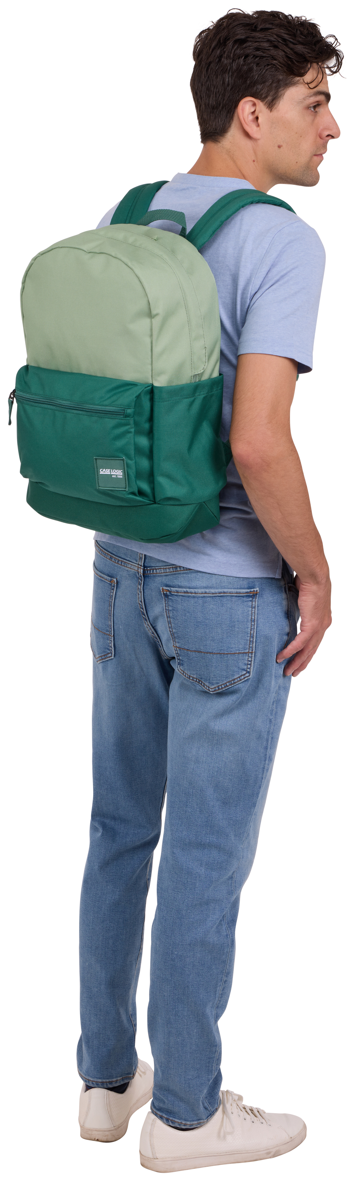 Mann mit grünem Rucksack und blauer Jeans steht rechts. Der Hintergrund ist weiß.