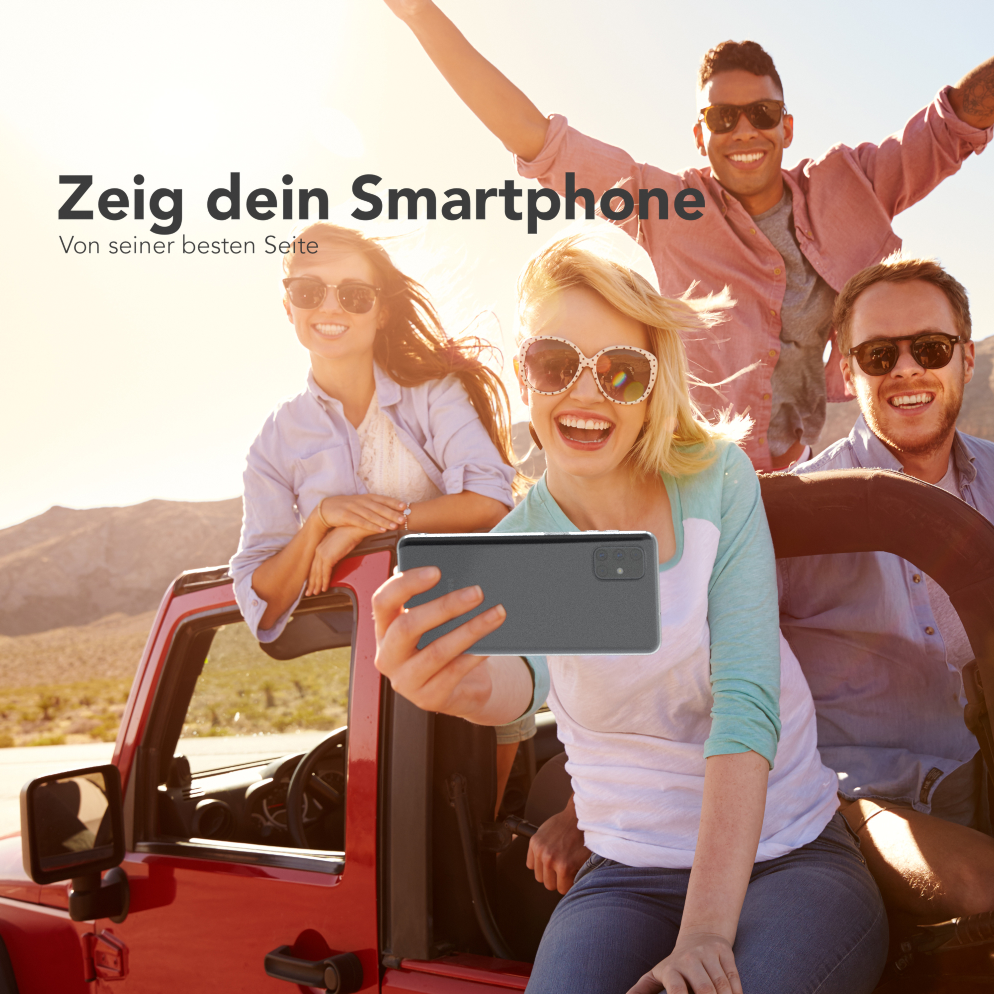 Vier Personen in einem Auto machen ein Selfie mit einem Telefon. Text lautet 'Zeig dein Smartphone'.