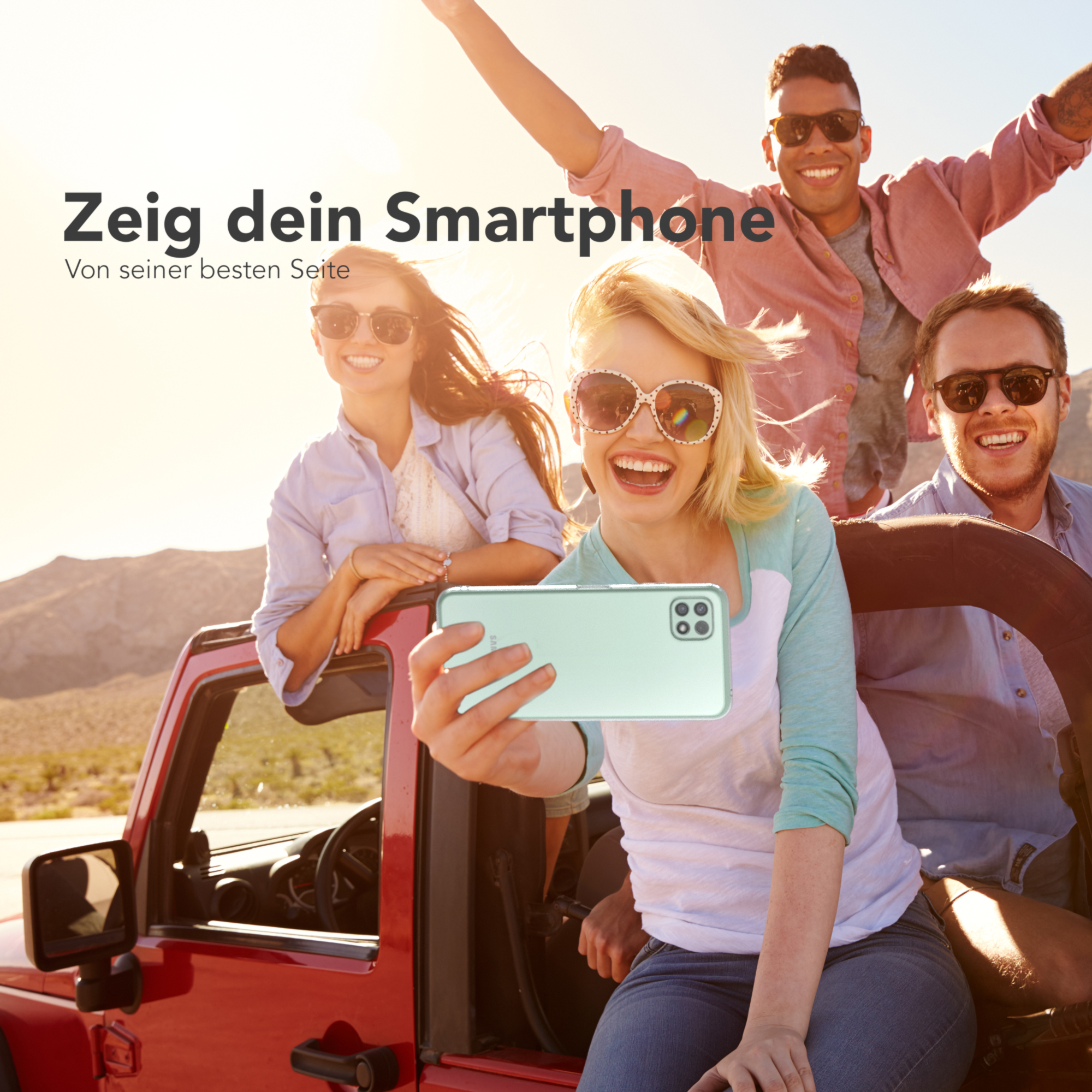 Vier Personen machen Selfie, eine hält grünes Telefon, in rotem Auto.