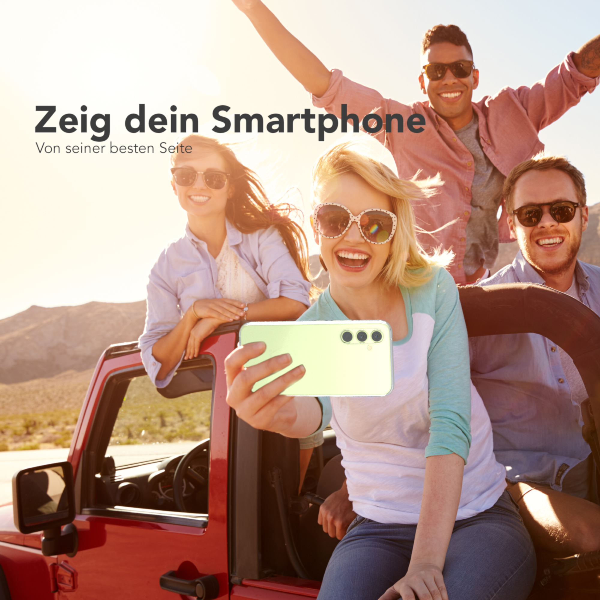 Eine Gruppe von Freunden macht ein Selfie in einem roten Jeep. Sonniger Hintergrund.