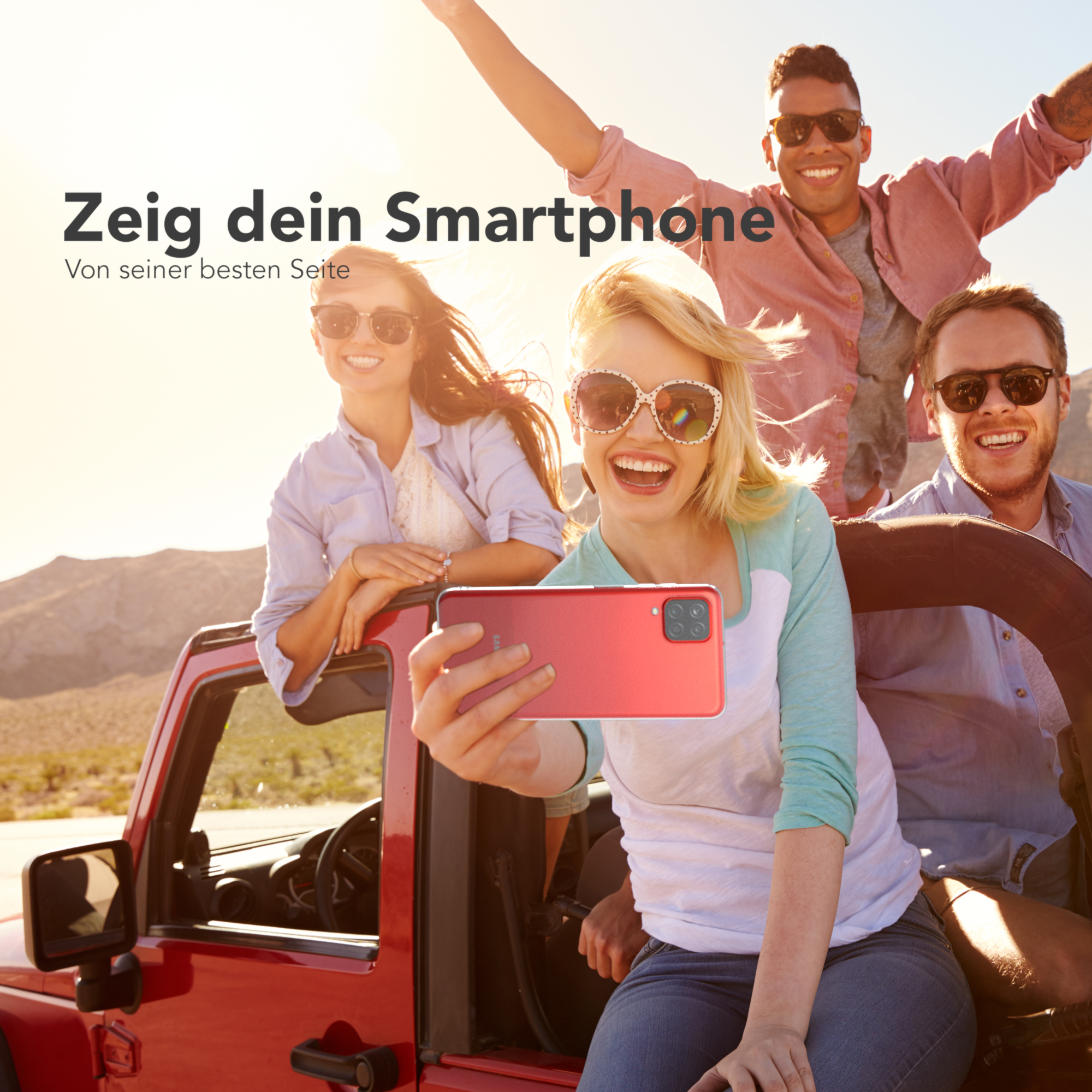 Gruppe von Leuten in rotem Auto macht Selfie mit rotem Telefon. Sonnig im Freien.