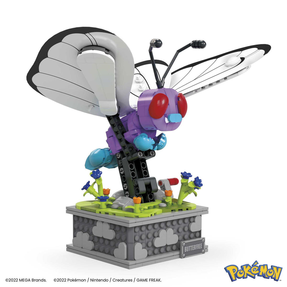 Model Lego Pokémon Butterfree z trawiastą podstawą i szarym tłem.