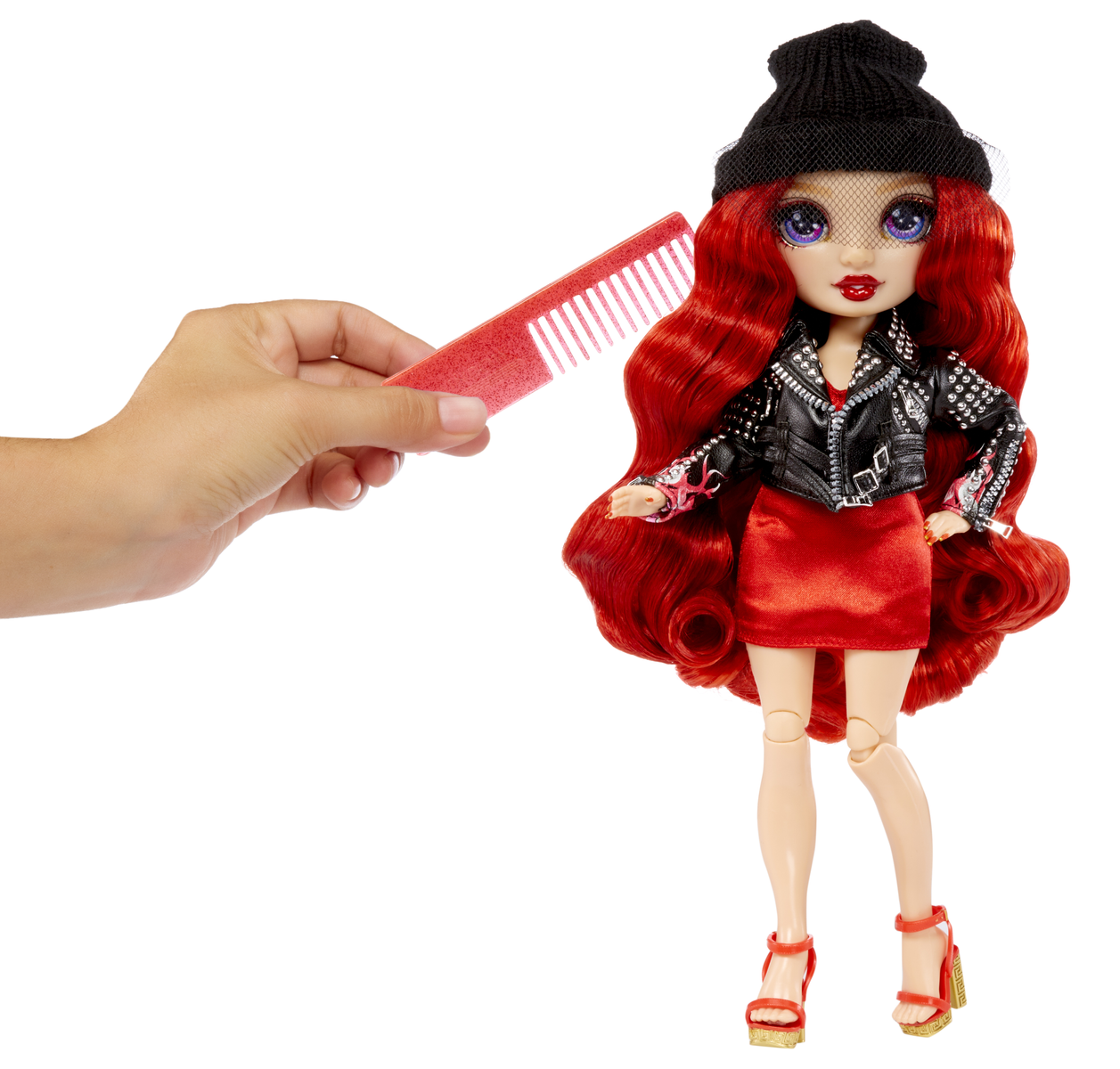 Lalka z rudymi włosami, grzebień w dłoni. Nosi czarny kapelusz i kurtkę.