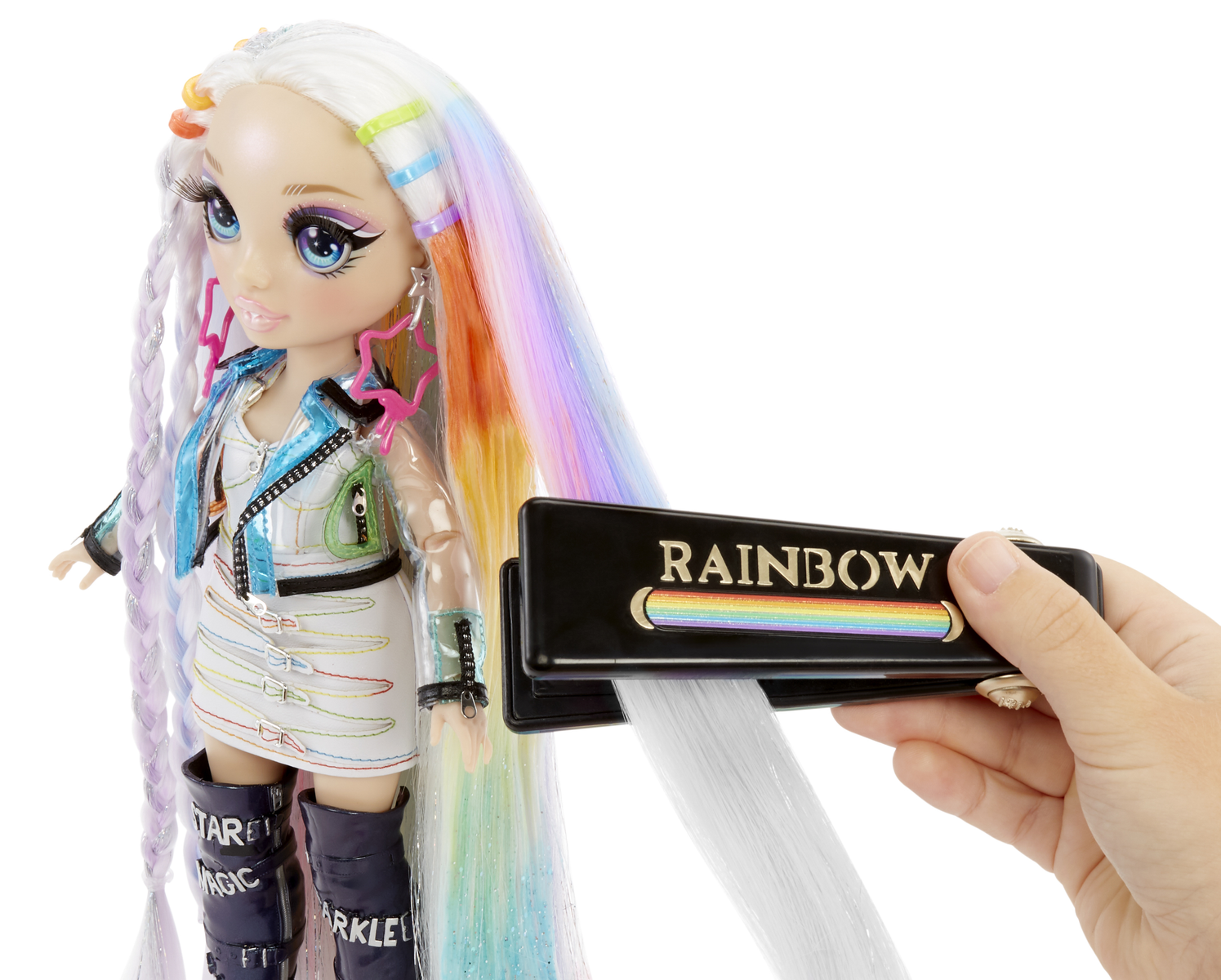 Eine Puppe mit langen, bunten Haaren. Eine Hand hält einen schwarzen Kamm mit dem Wort 'RAINBOW'.