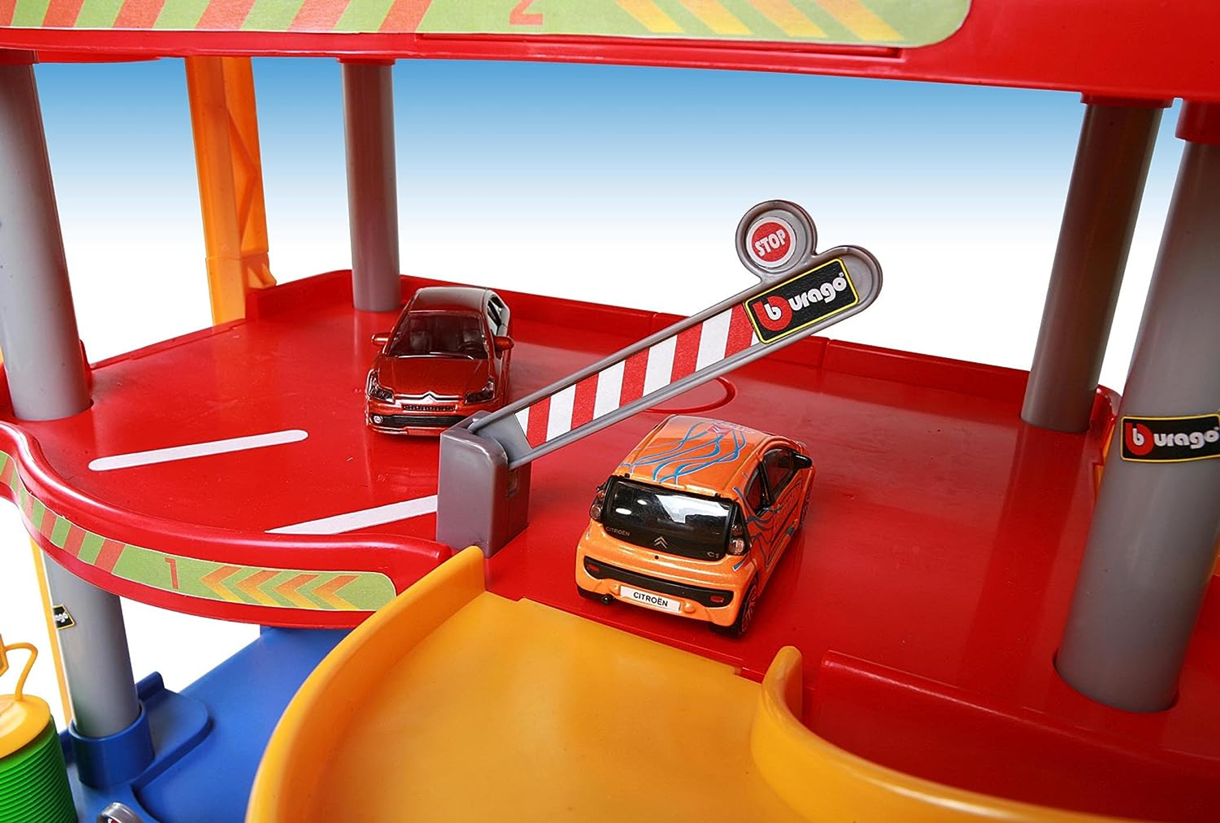Un juego de coches de juguete con dos coches y una barrera en la parte superior del estacionamiento.