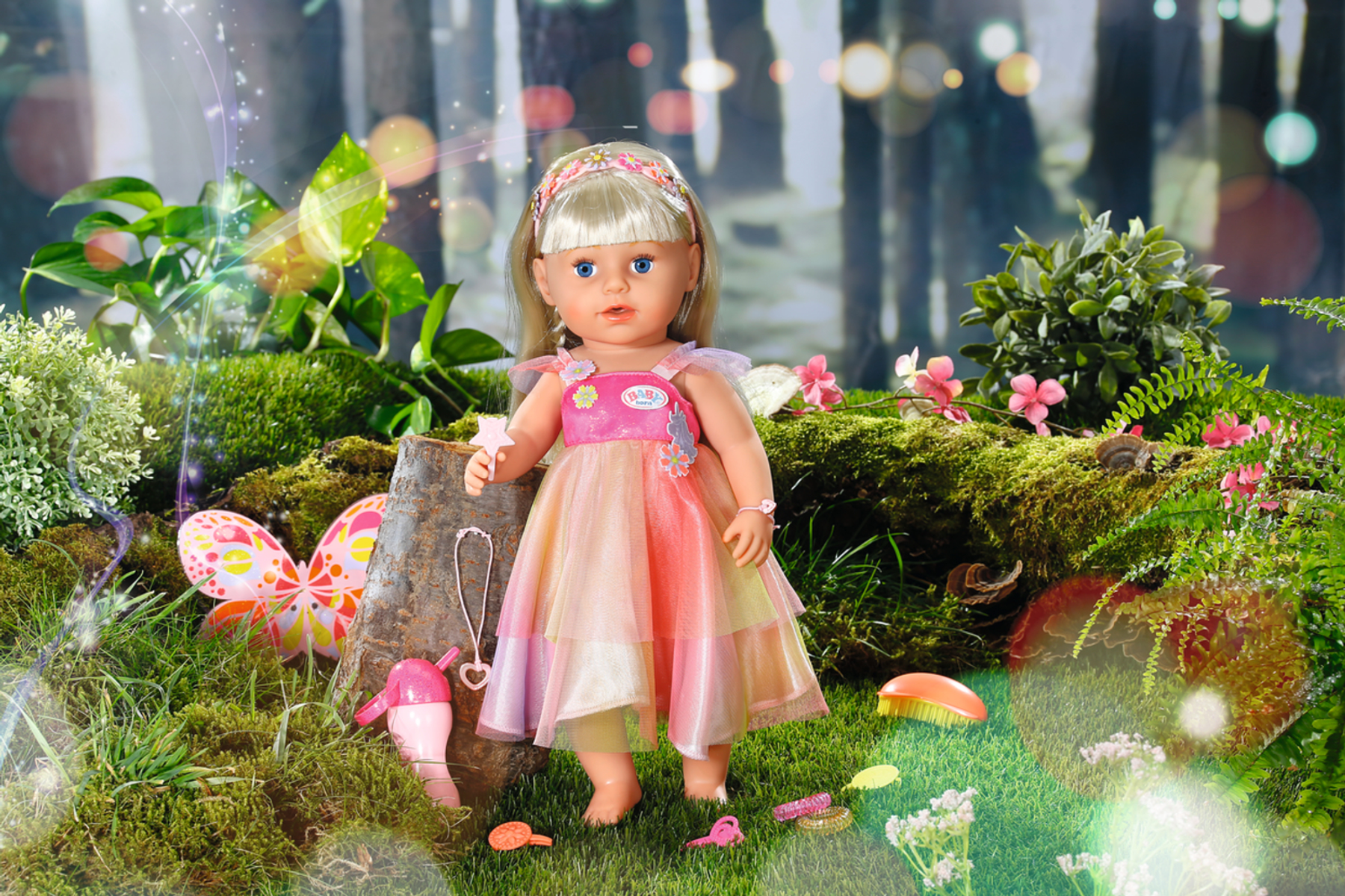 Eine Puppe in einem märchenhaften Kleid steht in einem Wald mit Accessoires herum.