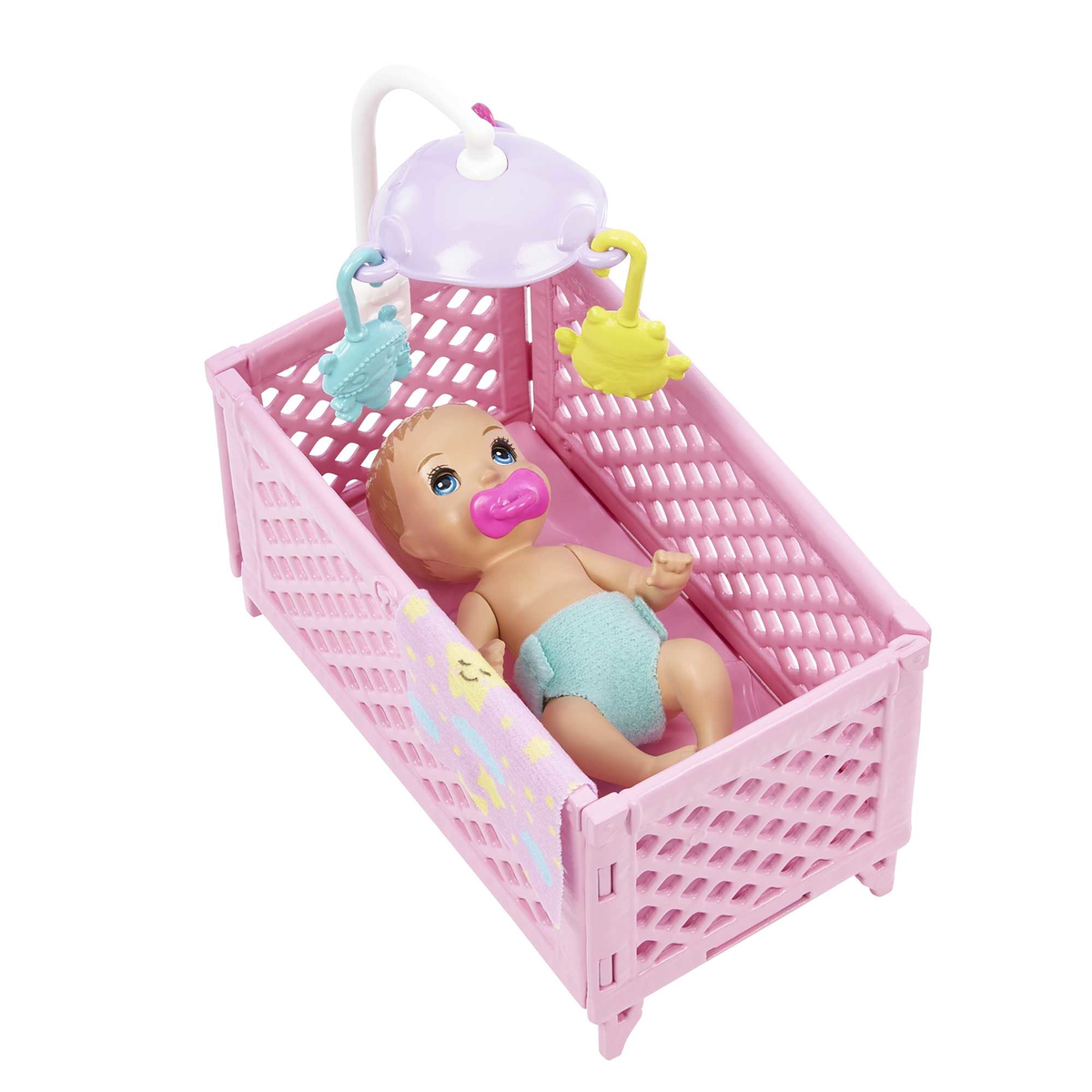 Eine Babypuppe liegt in einem rosa Plastikbett mit Mobile und Decke.
