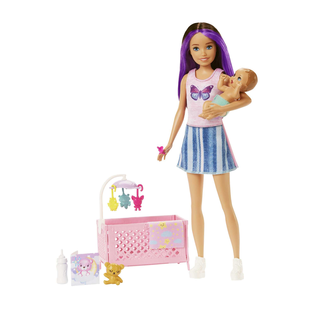 Eine Puppe hält eine Babypuppe in der Nähe eines Kinderbettes mit Spielzeug und Flaschen.