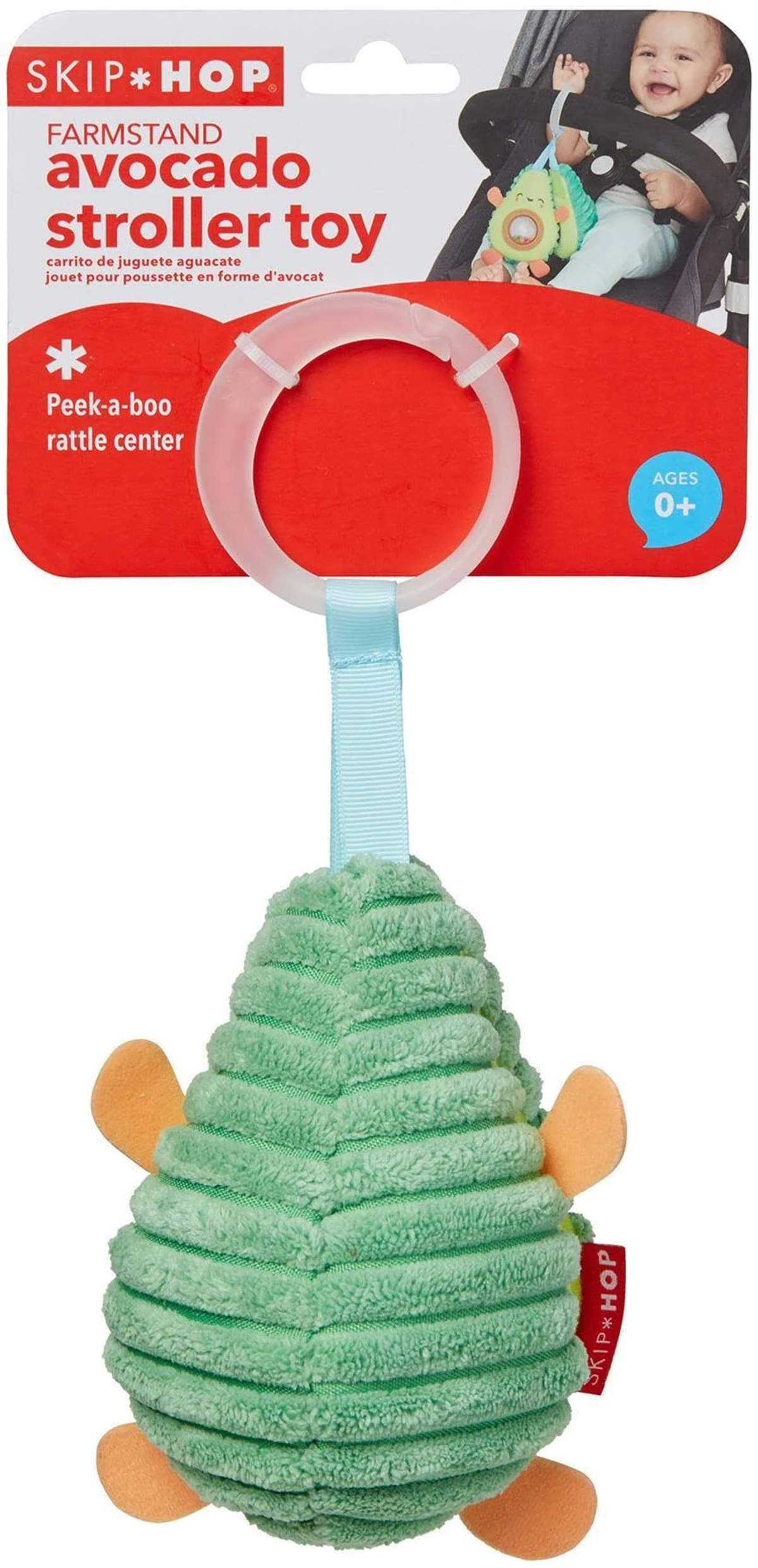 Ein grünes, avocado-förmiges Babyspielzeug mit Rassel und blauem Gurt an rotem Etikett.