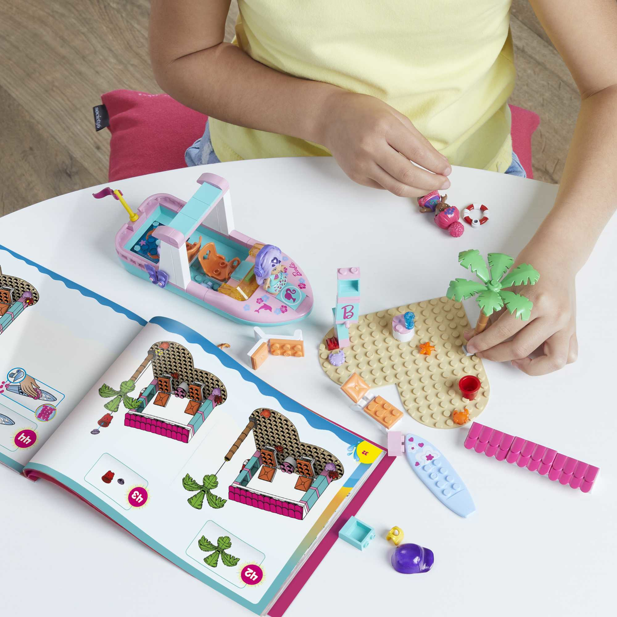 Dziecko bawi się zabawką w kształcie łódki i klockami. Widoczna jest również otwarta książka.