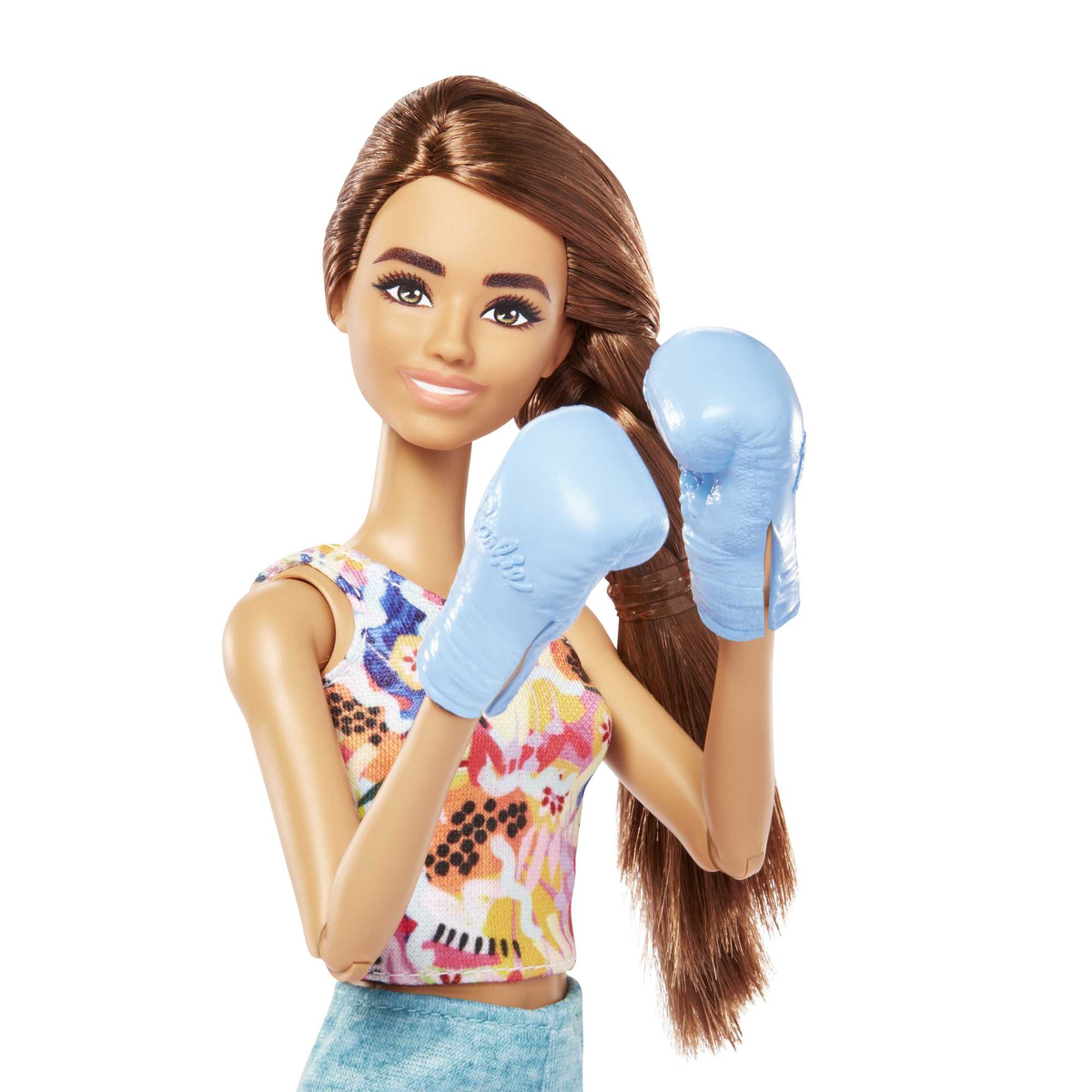 Eine Barbie-Puppe mit einem Oberteil mit Blumenmuster und Boxhandschuhen, die mit Fäusten posiert.