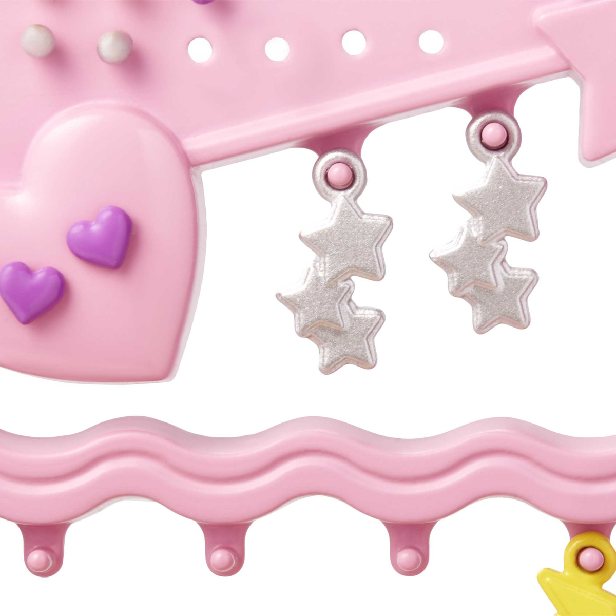 Artículo decorativo rosa con formas de corazón y estrella, y múltiples estrellas colgantes.