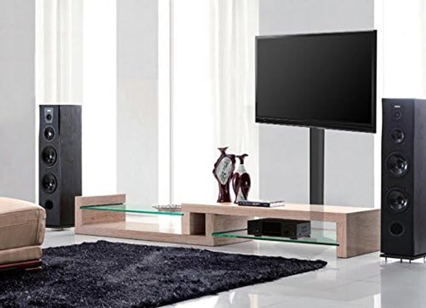 Wohnzimmer-Setup mit TV, Lautsprechern und Möbeln.