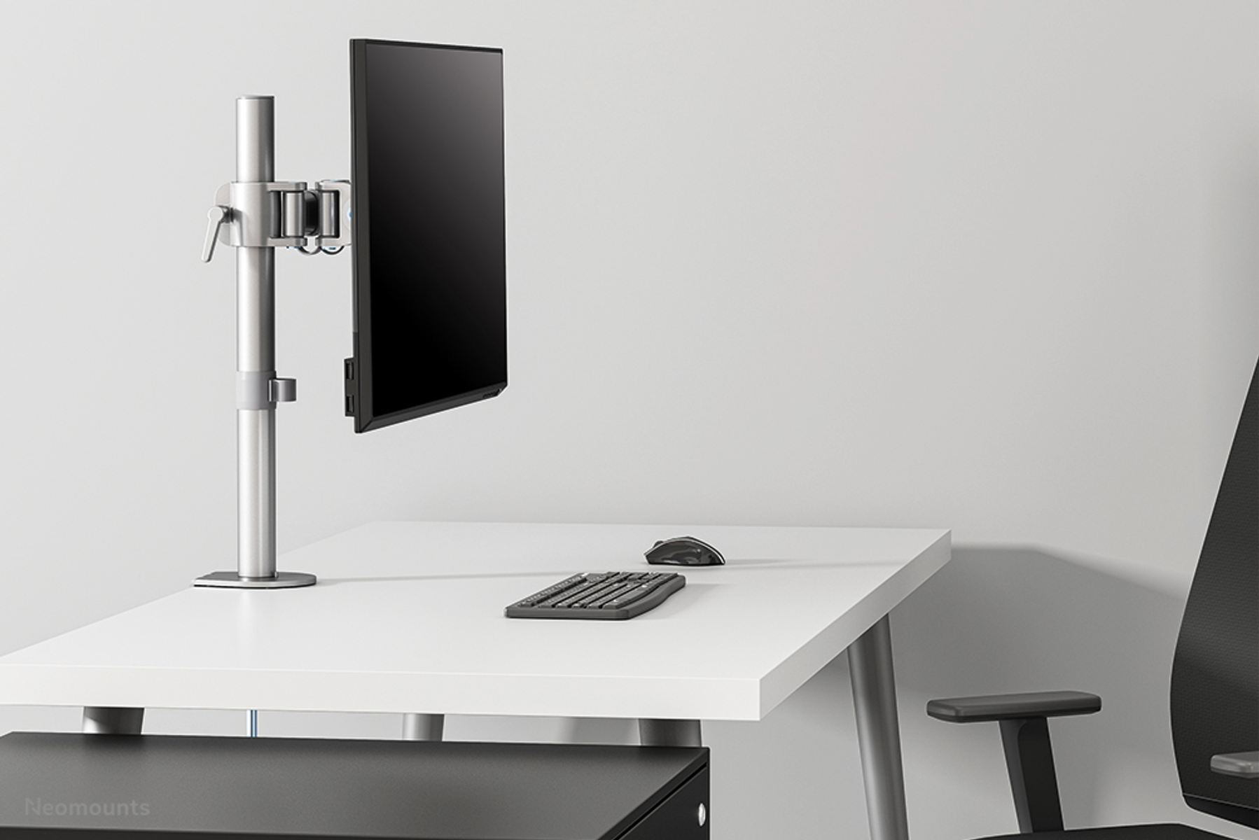 Monitor arm with a black monitor, mouse, and keyboard on a white desk.