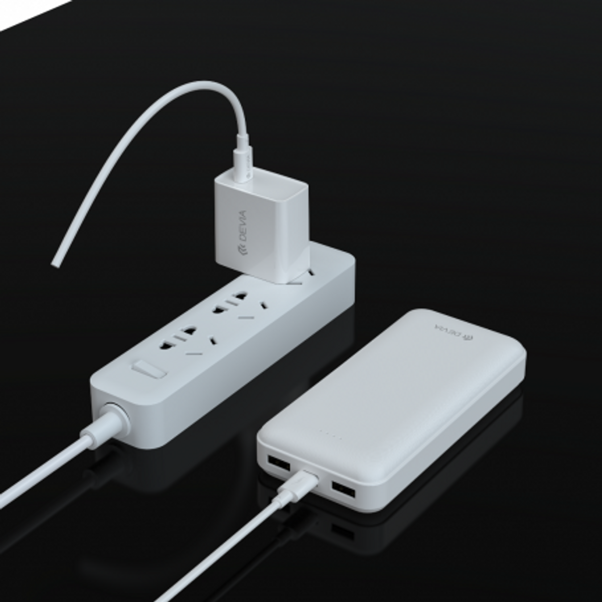 Presa multipla bianca con caricatore e power bank collegati, su superficie nera.
