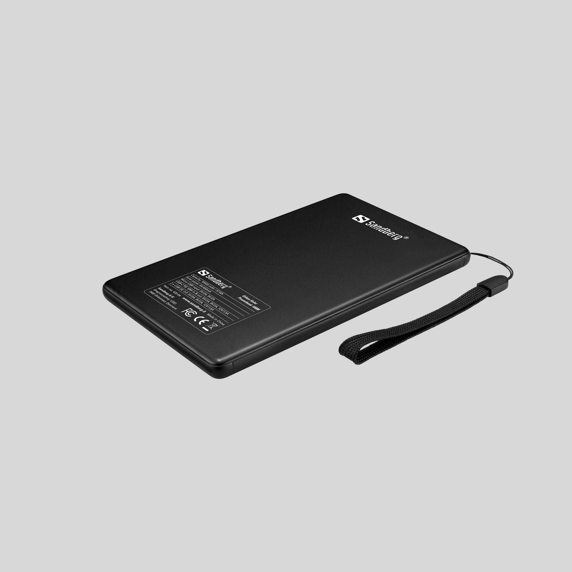 Schwarze Sandberg Powerbank mit Handschlaufe auf hellgrauem Hintergrund.
