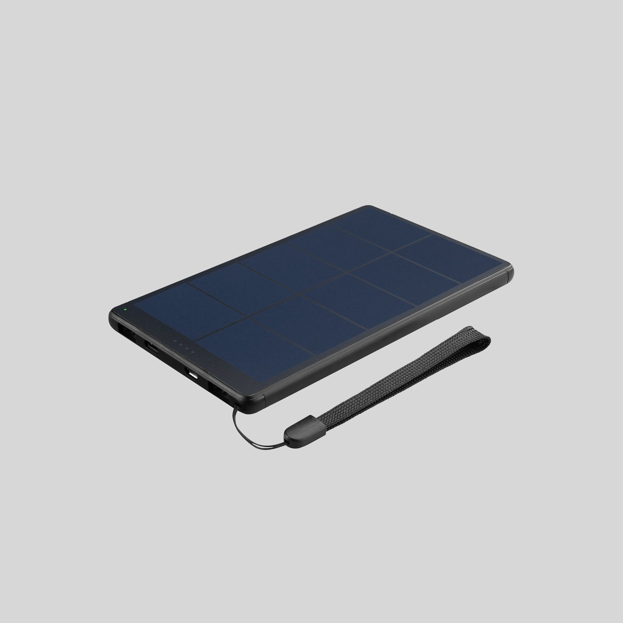 Eine schwarze, solarbetriebene Powerbank mit Handschlaufe auf grauem Hintergrund.
