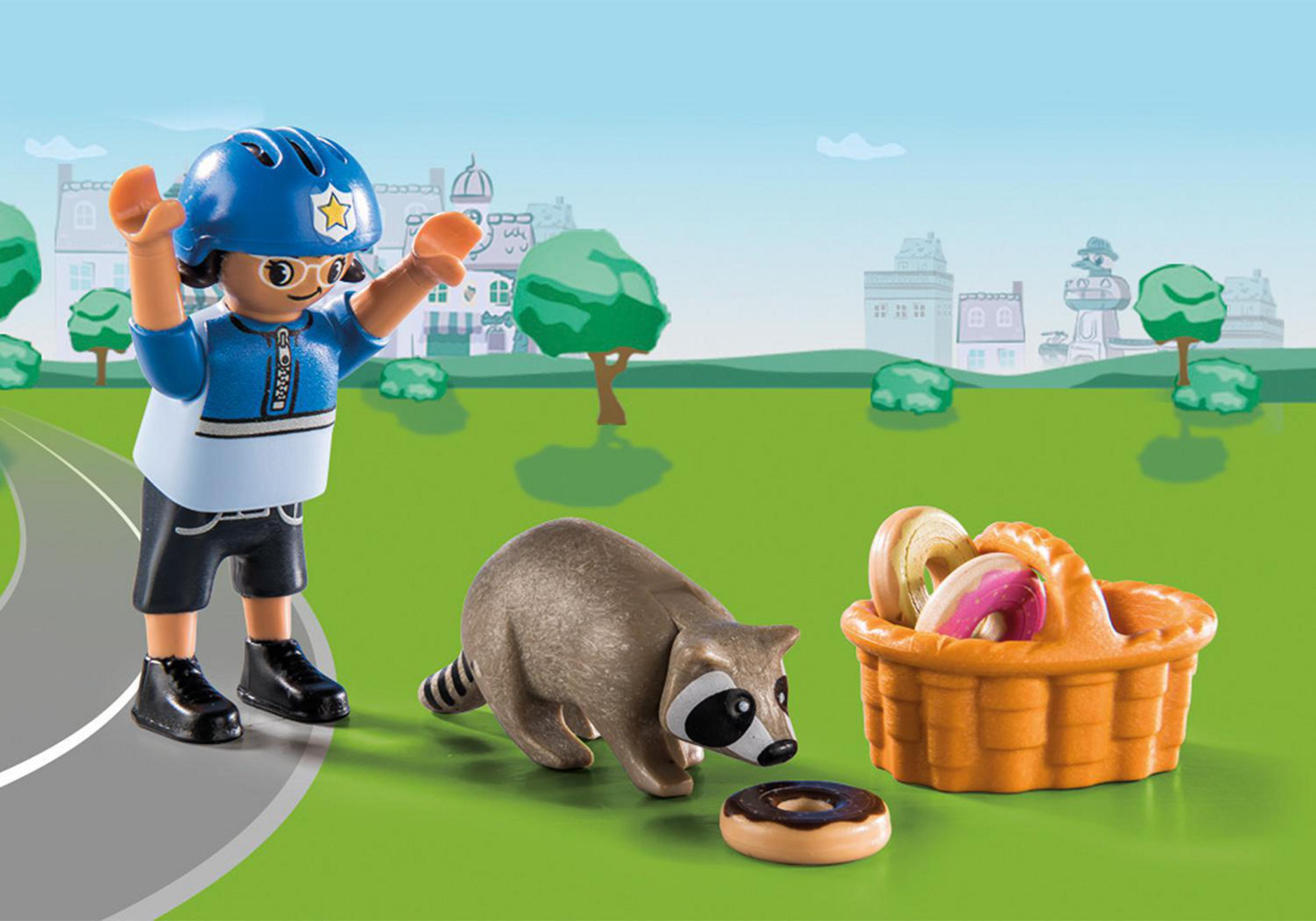Un bambino in uniforme blu con un procione, una ciambella e un cestino di ciambelle in una scena del parco.