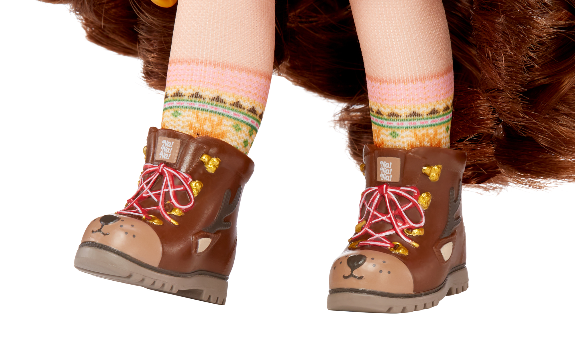 Zbliżenie stóp lalki w brązowych butach z twarzami jeleni i różowych skarpetach na białym tle.