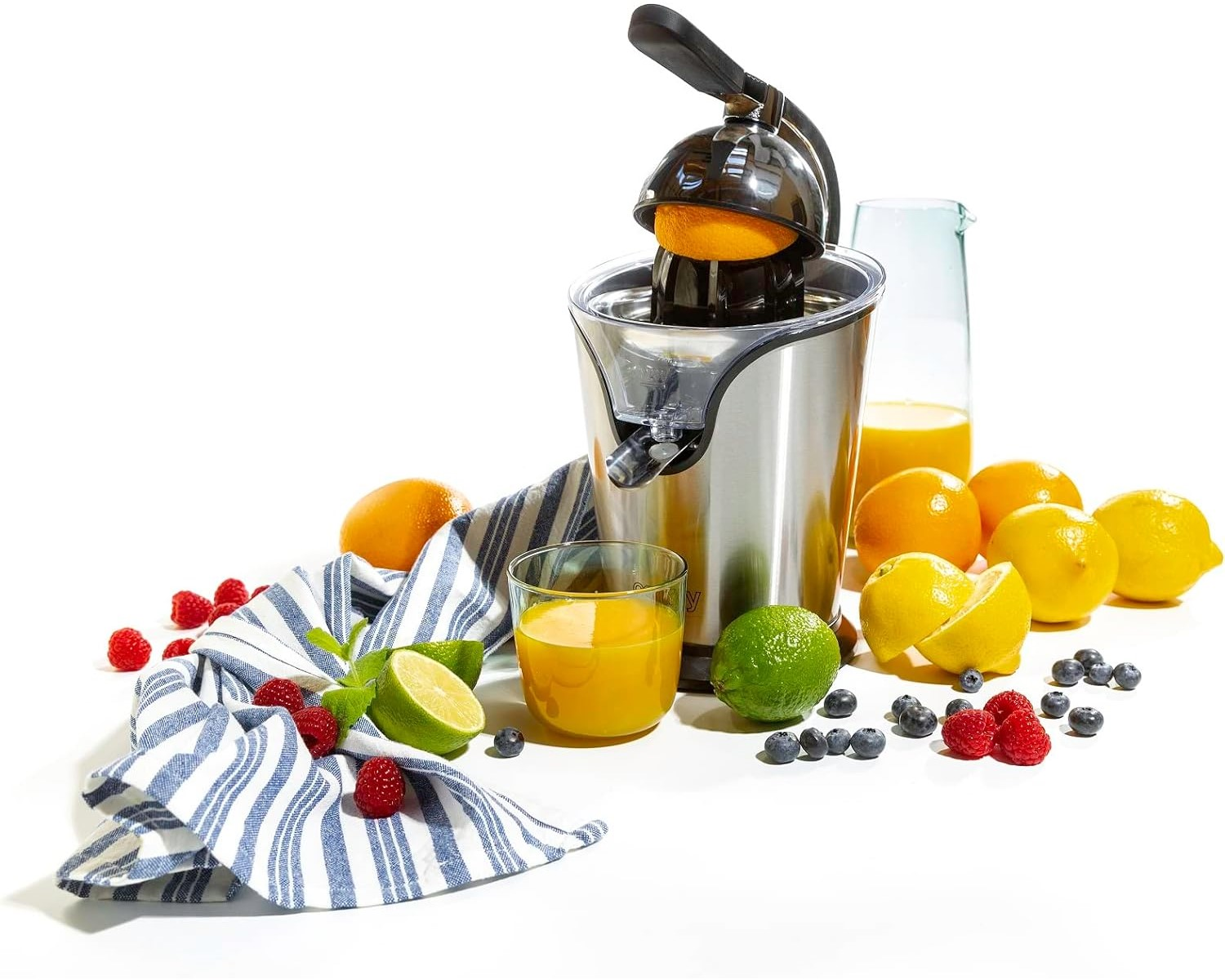 Entsafter mit Orangen, Zitronen, Limetten, Beeren und Saftglas auf weißem Hintergrund.