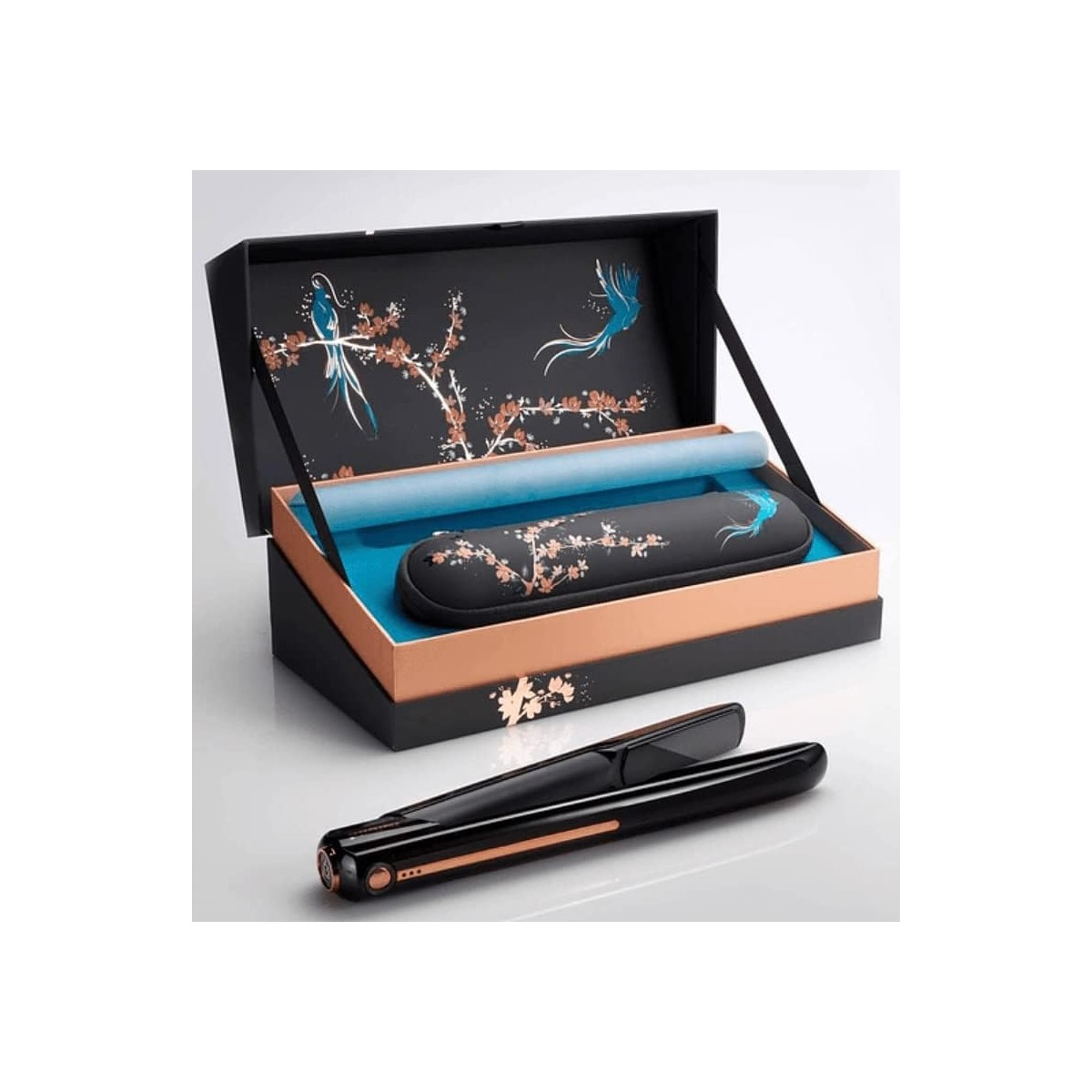 Haarglätter-Set in einer verzierten Box. Die Box ist schwarz und gold mit floralem Design.
