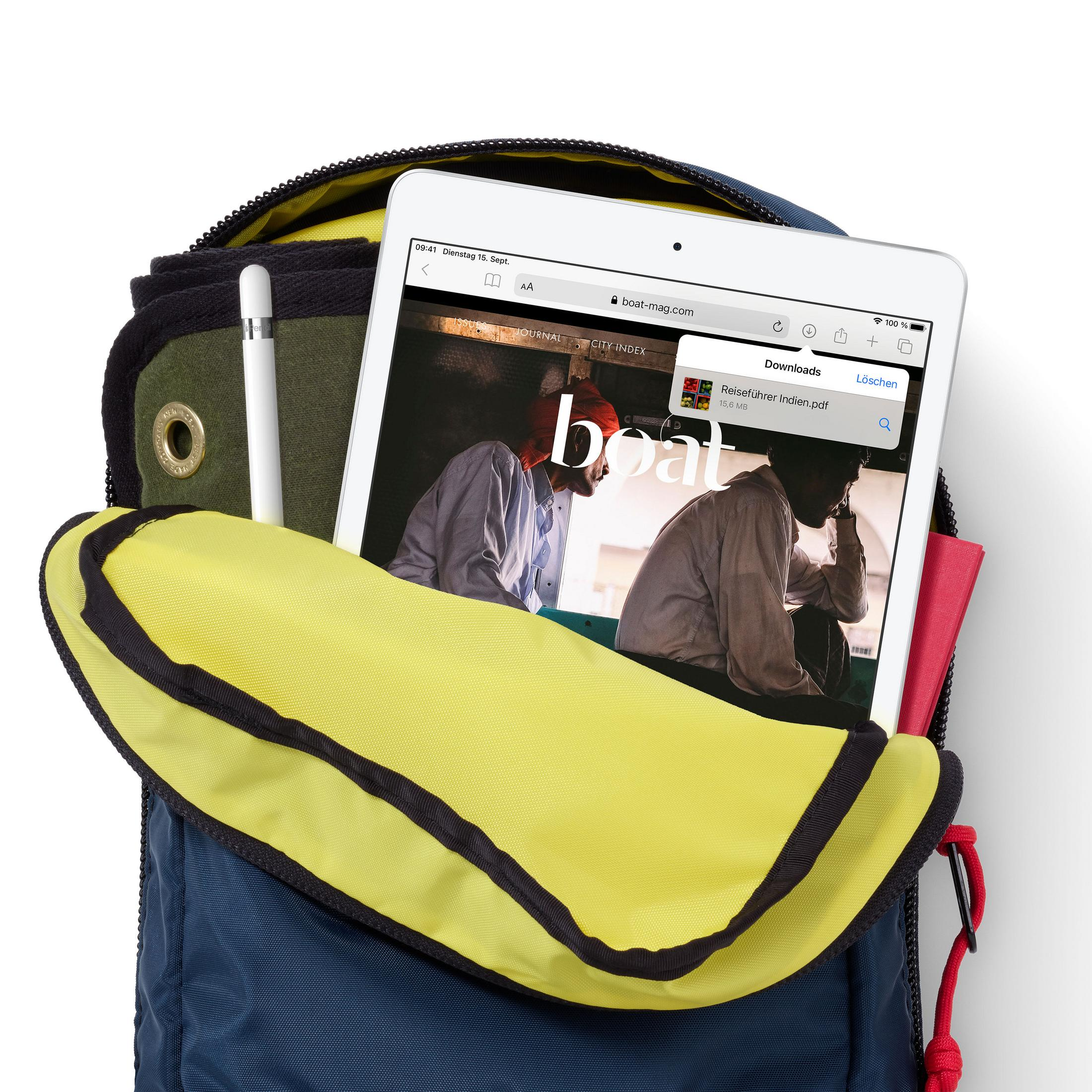 Tablet i ołówek w plecaku. Tablet wyświetla stronę internetową. Żółta i niebieska torba.