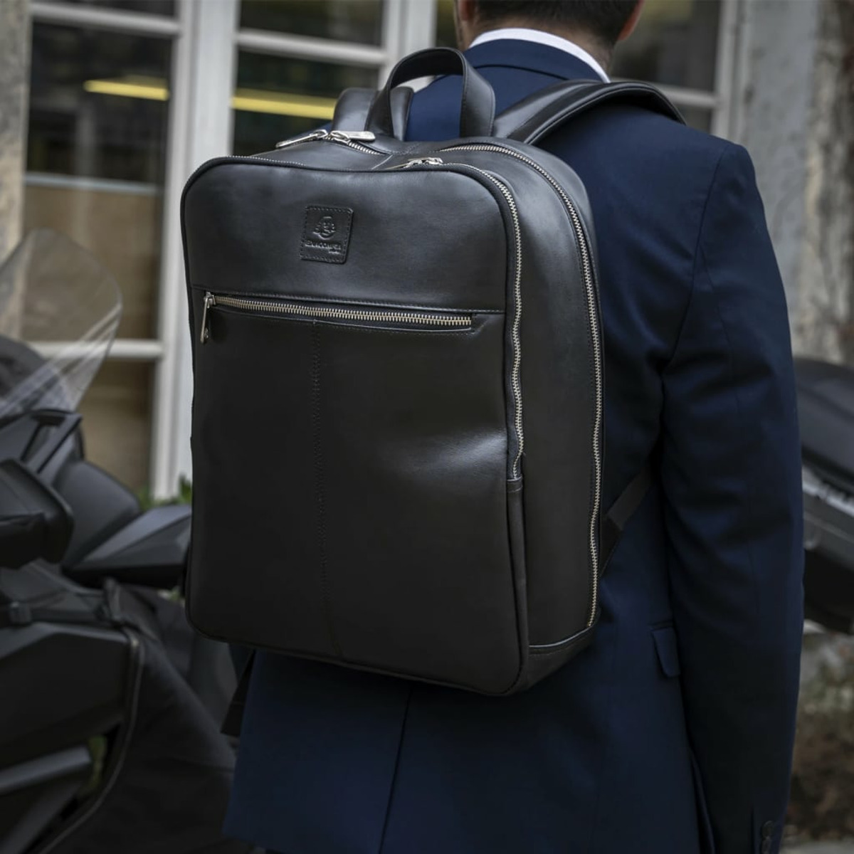 Una persona con un traje con una mochila negra en la espalda.