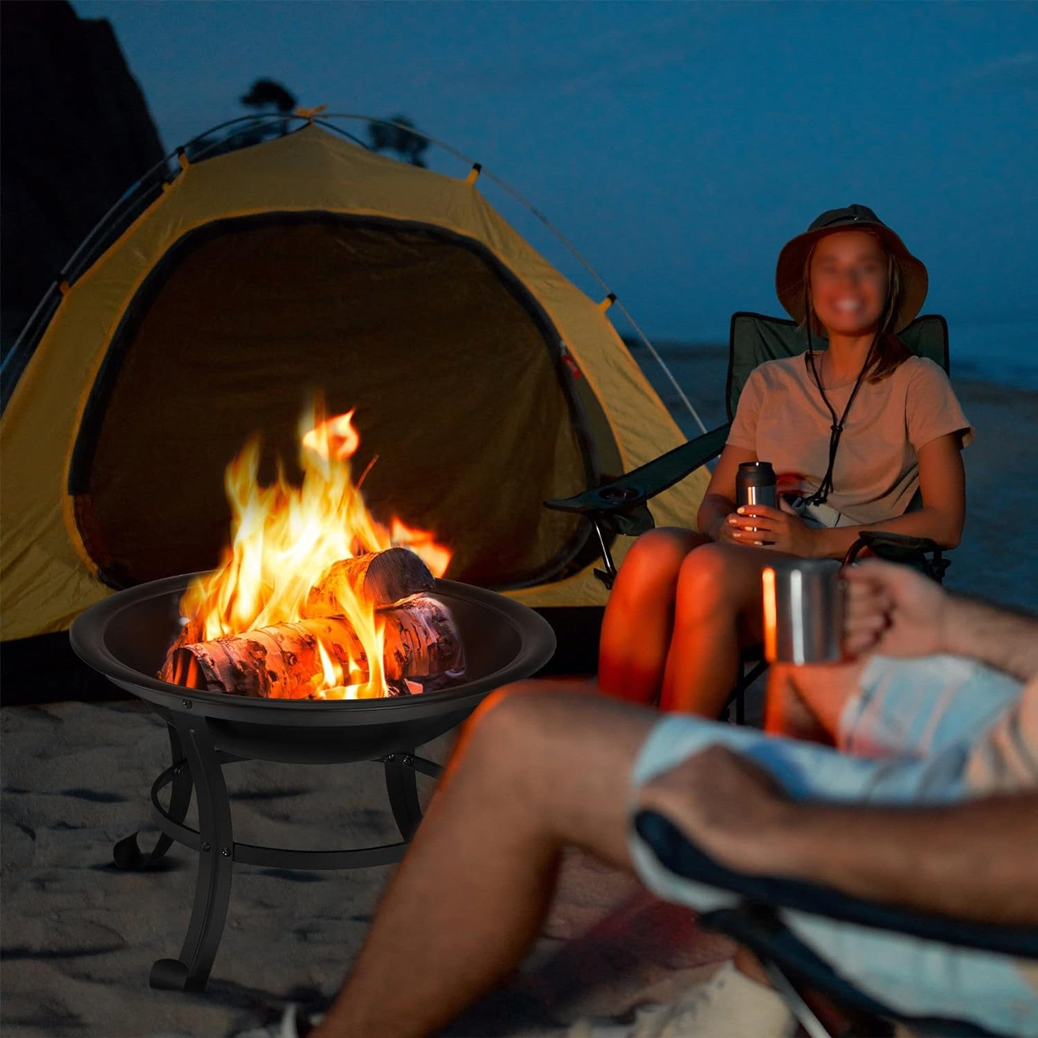 Lagerfeuer mit Zelt und Personen, zwei Personen sitzen. Nachtszene am Strand.