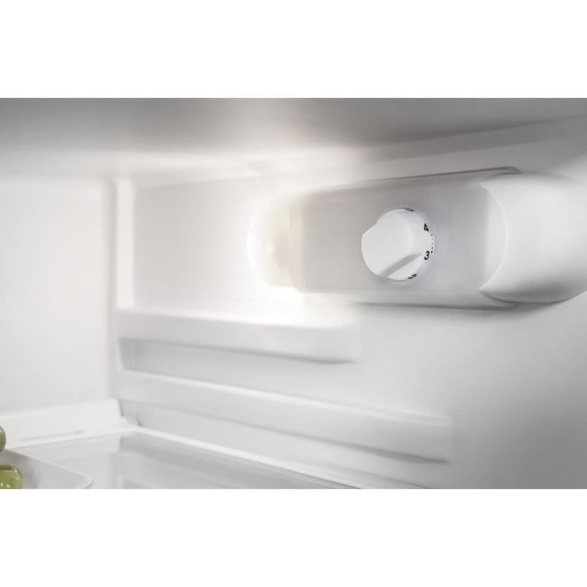 Interno di un frigorifero bianco con luce e manopola.